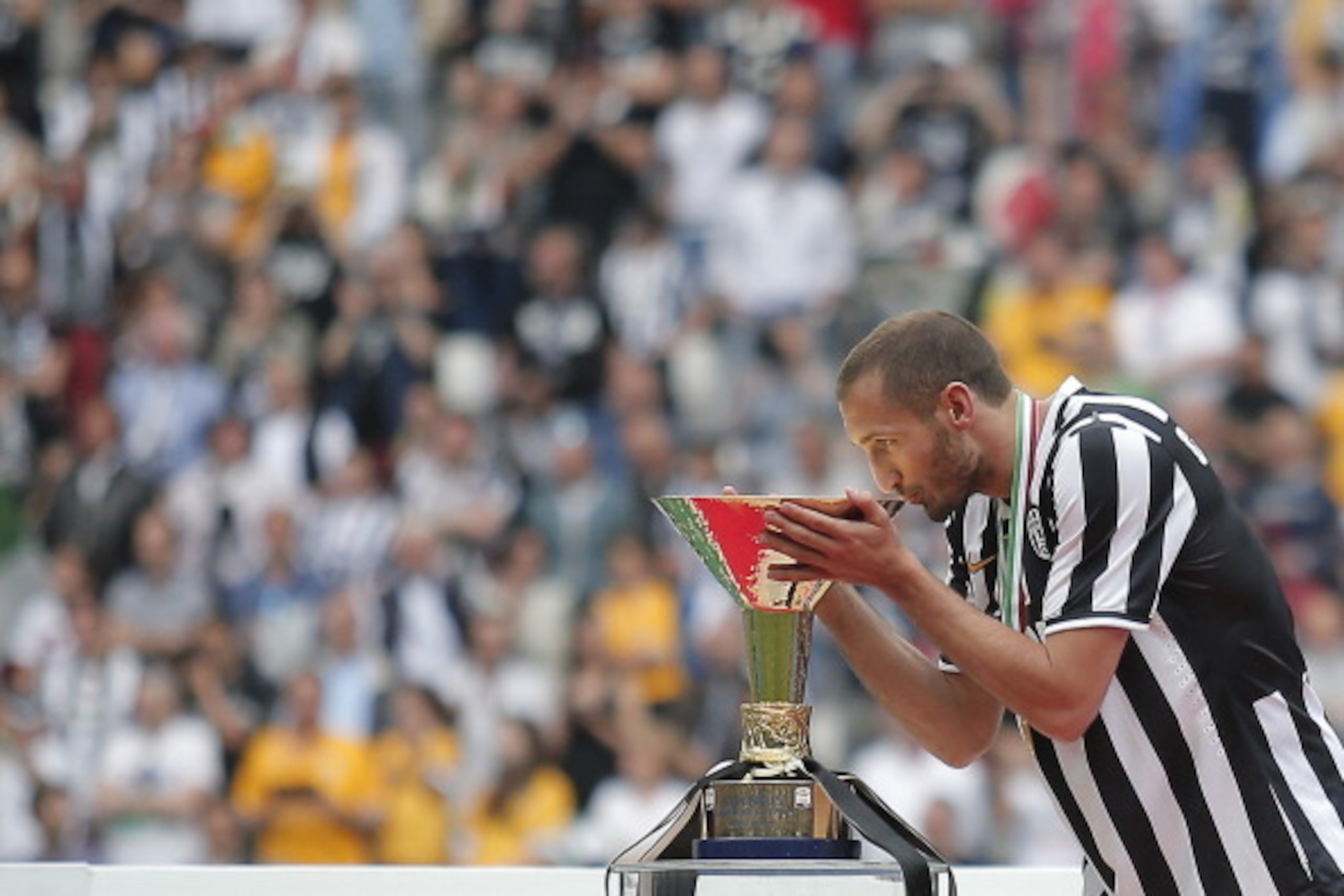 Juventus' defender Giorgio Chiellini kisses the trophy after Juventus won the 'scudetto', the Italian Serie A championship after their last game against Cagliari on May 18, 2014 in Juventus Stadium in Turin. Juventus won their third consecutive 'scudetto' Juventus' defender Giorgio Chiellini kisses the trophy after Juventus won the 'scudetto', the Italian Serie A championship after their last game against Cagliari on May 18, 2014 in Juventus Stadium in Turin. Juventus won their third consecutive 'scudetto'