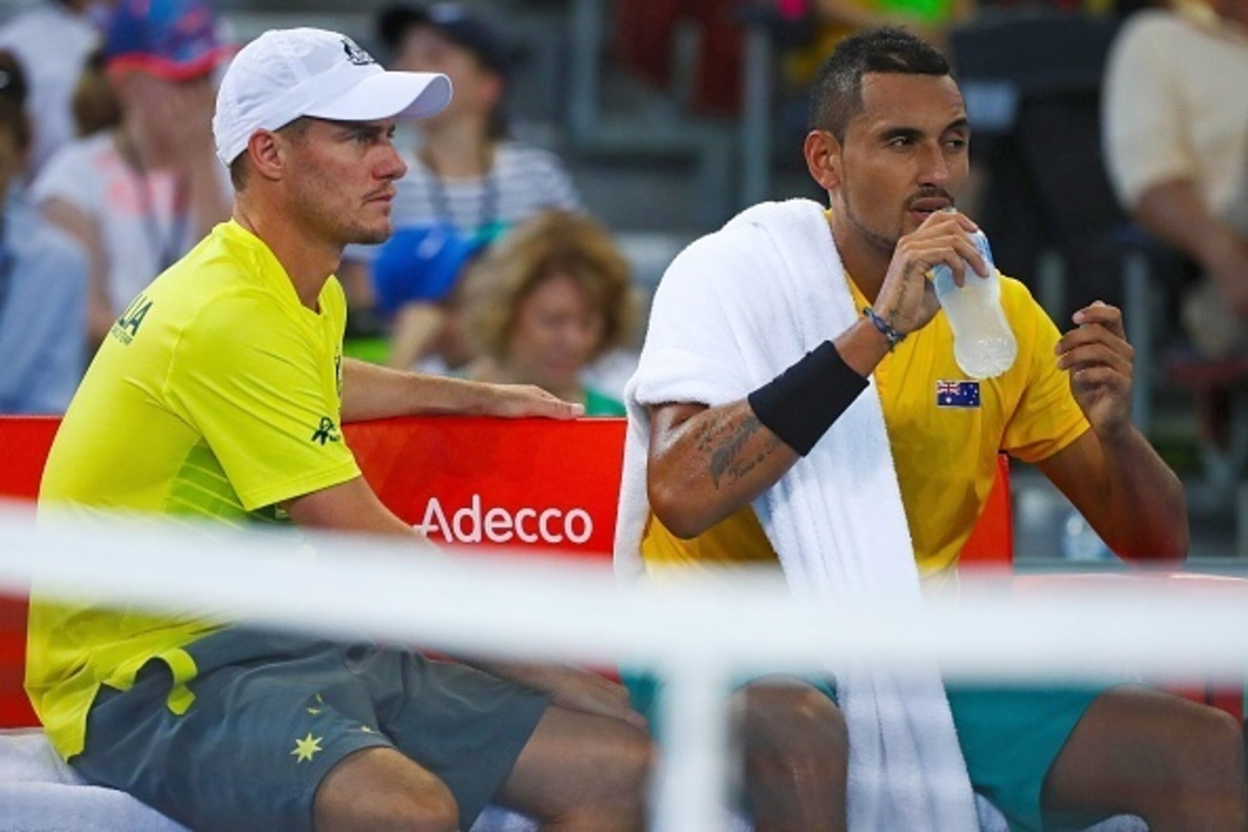 Nick Kyrgios of Australia (R) sits with team captain Lleyton Hewitt during his tennis match against John Isner of the US in the world group quarter-final Davis Cup clash between Australia and the USA at the Pat Rafter Arena in Brisbane on April 7, 2017.  