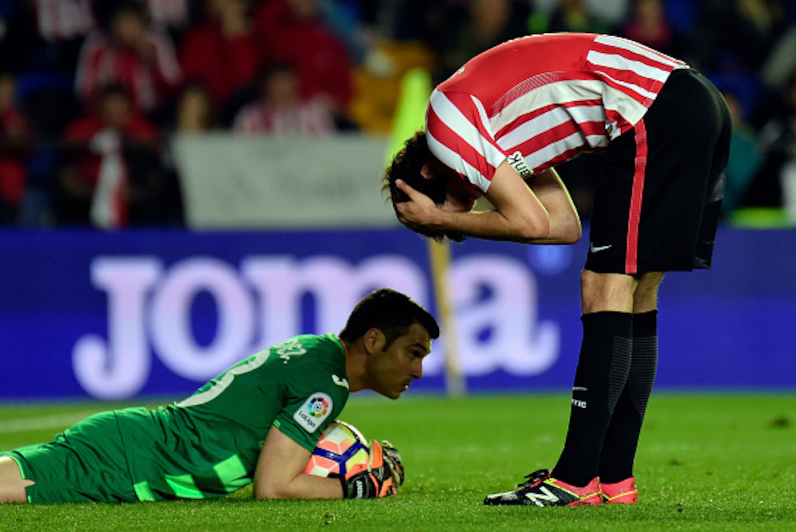 Athletic's midfielder Mikel San Jose (R) bends in front of Villarreal's goalkeeper Andres Fernandez after missing an attempt on goal during the Spanish league football match Villarreal CF vs Athletic Club Bilbao at El Madrigal stadium in Vila-real on Apri