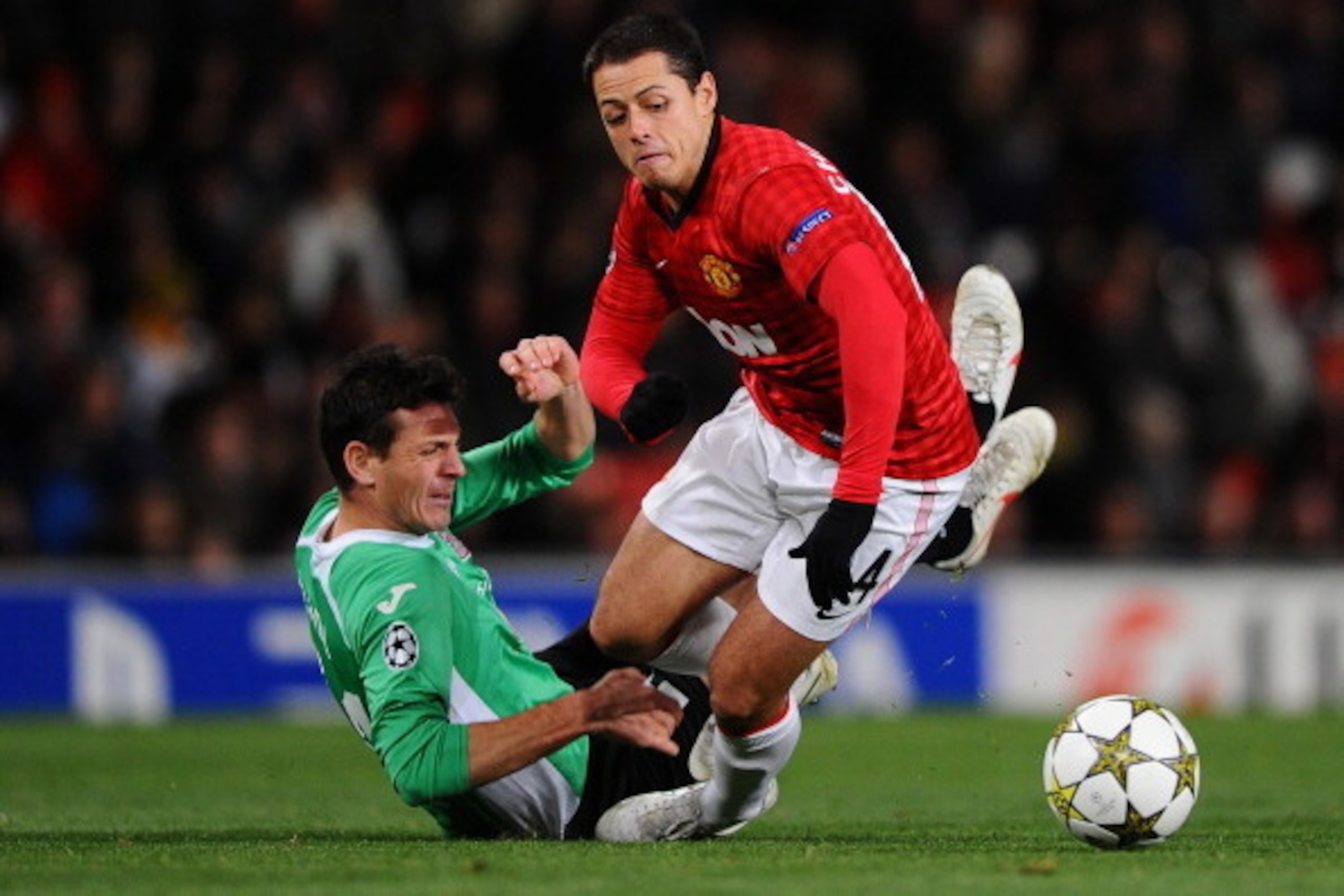 MANCHESTER, ENGLAND - DECEMBER 05:  Javier Hernandez of Manchester United is brought down by Ionut Rada of CFR 1907 Cluj during the UEFA Champions League Group H match between Manchester United and CFR 1907 Cluj at Old Trafford on December 5, 2012 in Manc