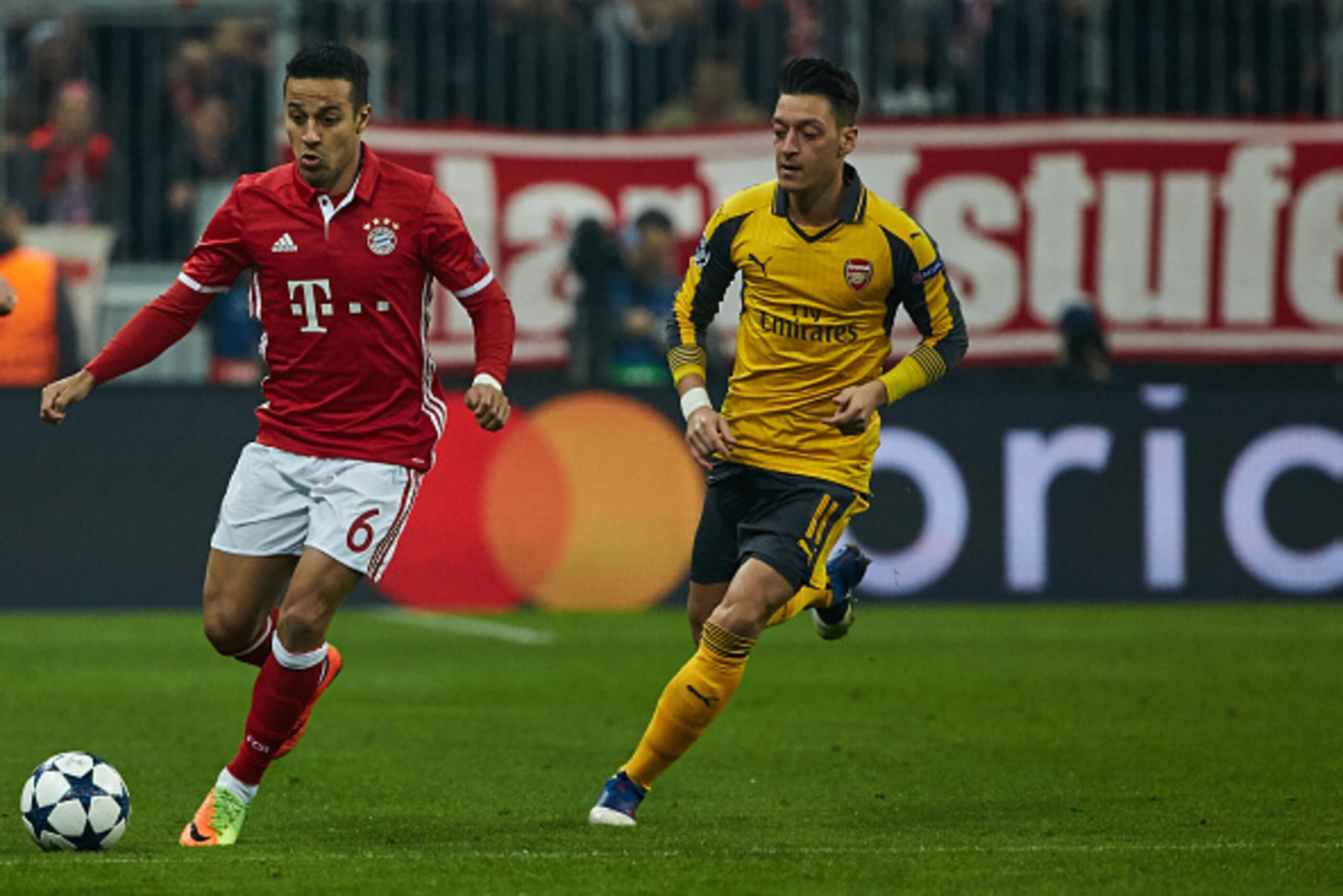 Munich, GERMANY - FEBRUARY 15: Thiago of Bayern Munich and Mesut Oezil of Arsenal battle for the ball during the UEFA Champions League Round of 16 first leg match between FC Bayern Muenchen and Arsenal FC at Allianz Arena on February 15, 2017 in Munich, G