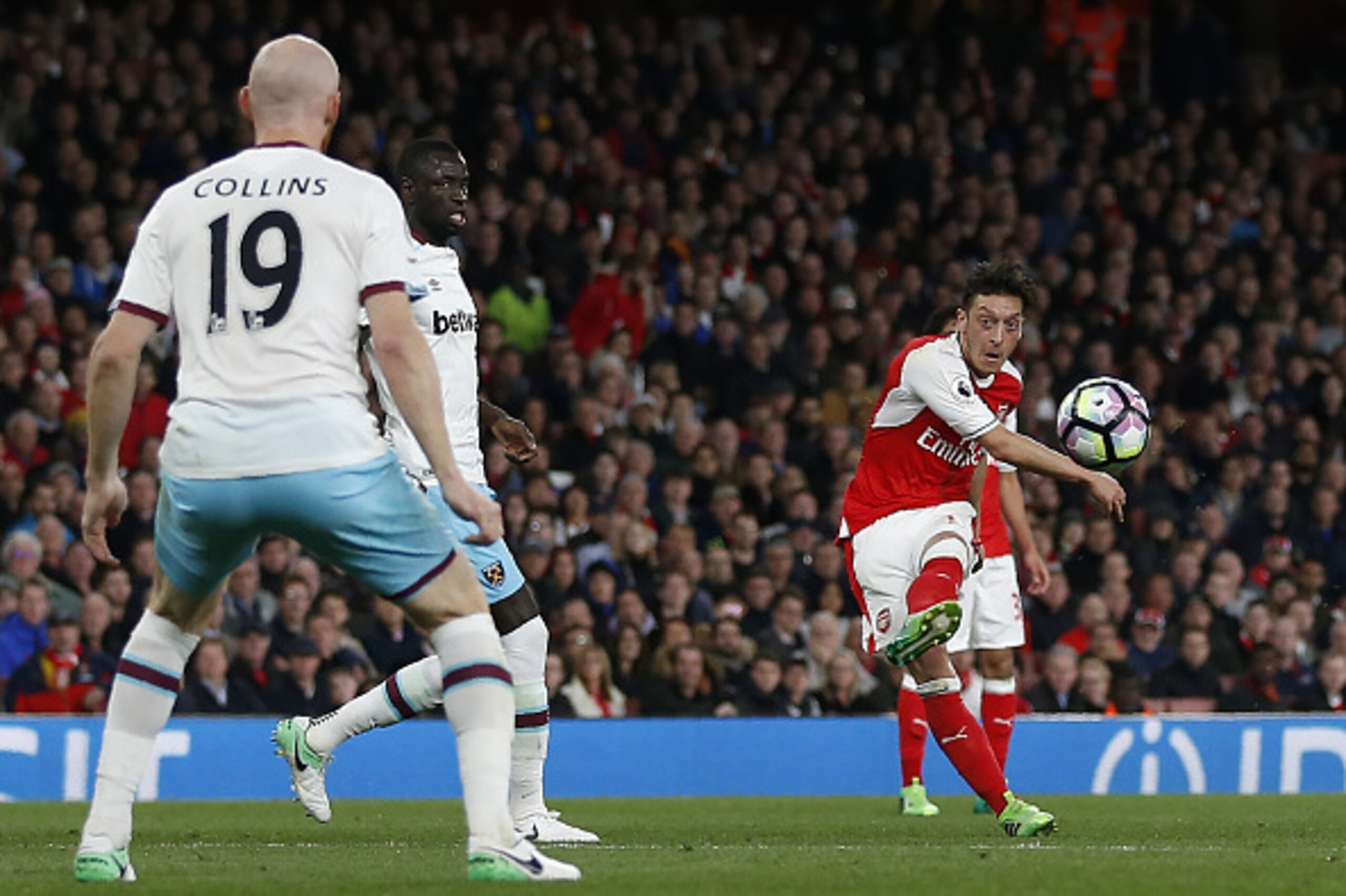 Arsenal's German midfielder Mesut Ozil (R) shoots to score the opening goal of the English Premier League football match between Arsenal and West Ham United at the Emirates Stadium in London on April 5, 2017.  / AFP PHOTO / Ian KINGTON / RESTRICTED TO EDI