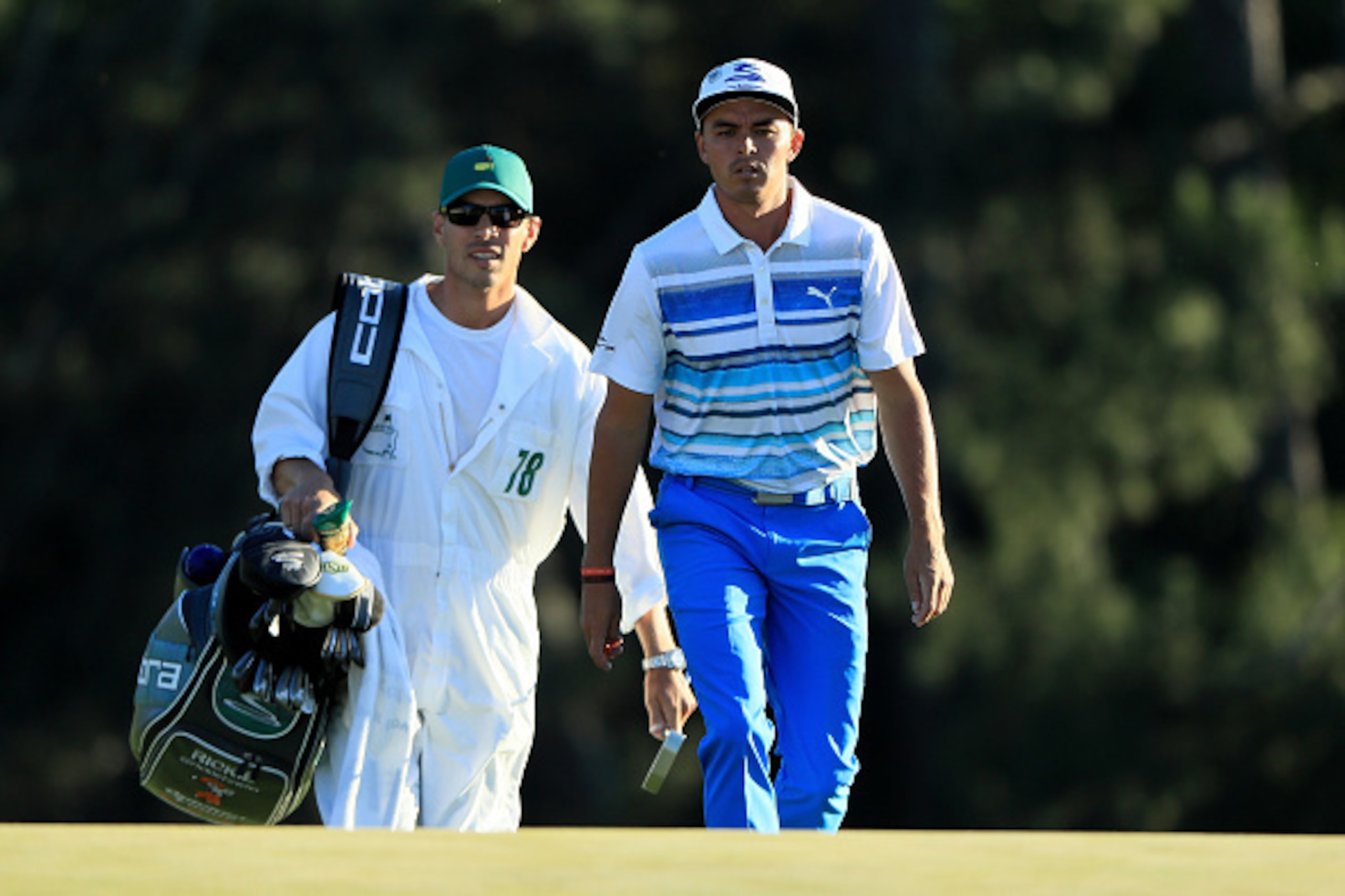 AUGUSTA, GA - APRIL 08:  Rickie Fowler of the United States and his caddie Joseph Skovron walk to the on the 18th hole green during the third round of the 2017 Masters Tournament at Augusta National Golf Club on April 8, 2017 in Augusta, Georgia.  (Photo 