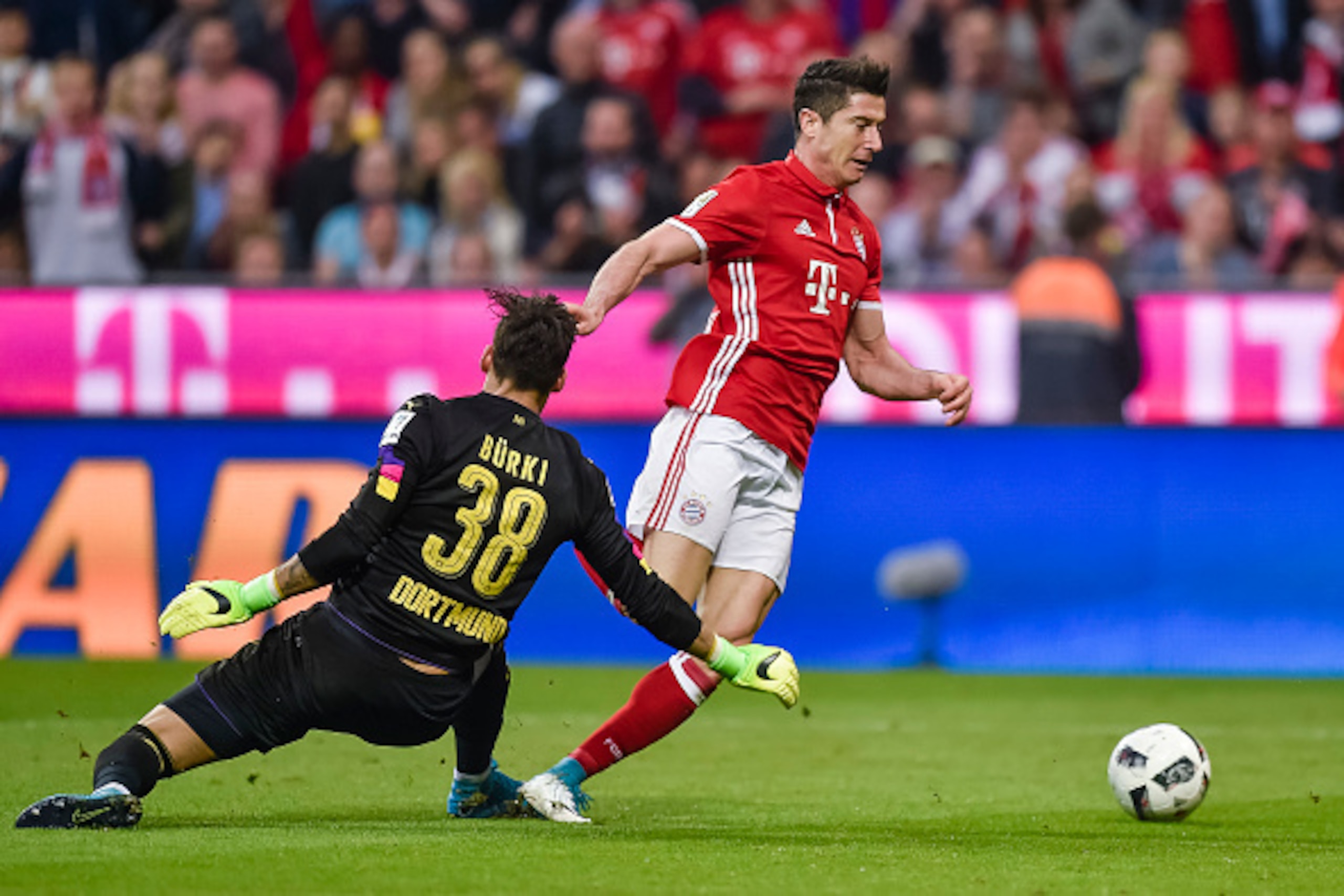 Dortmund's Swiss goalkeeper Roman Buerki (L) fouls Bayern Munich's Polish striker Robert Lewandowski during the German first division Bundesliga football match FC Bayern Munich v BVB Borussia Dortmund in Munich, southern Germany, on April 8, 2017. / AFP P