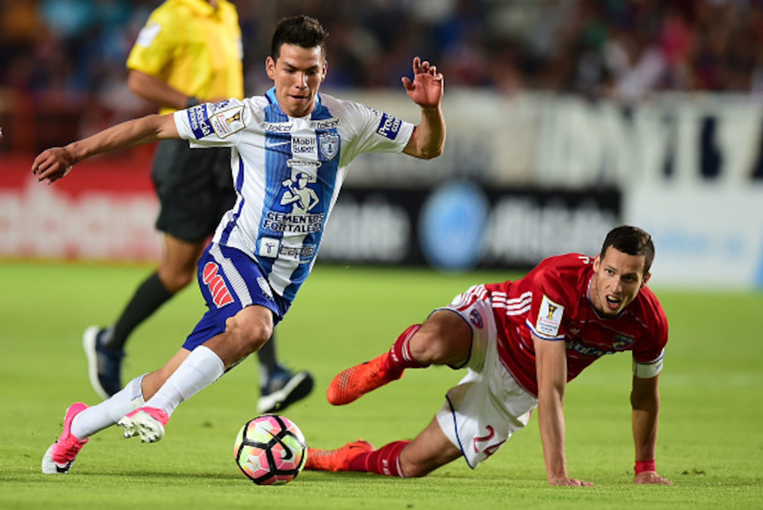 Mexico's Pachuca player Hirving Rodrigo Lozano (L) vies for the ball with Matt Hedges (R) of FC Dallas of the US, during their CONCACAF Champions League semifinal football match at the Miguel Hidalgo stadium in Pachuca, Hidalgo State, on April 4, 2017. / 