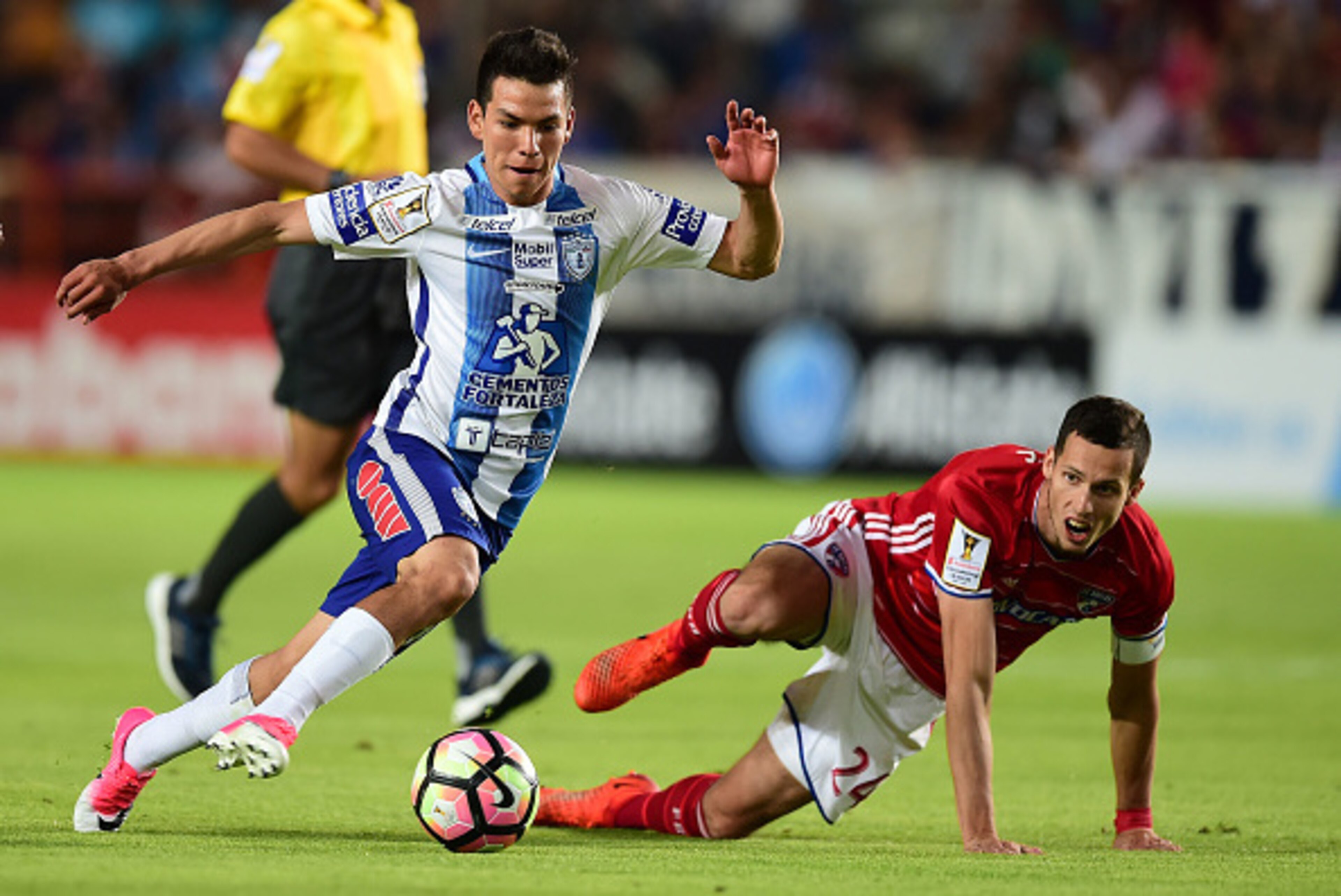 Mexico's Pachuca player Hirving Rodrigo Lozano (L) vies for the ball with Matt Hedges (R) of FC Dallas of the US, during their CONCACAF Champions League semifinal football match at the Miguel Hidalgo stadium in Pachuca, Hidalgo State, on April 4, 2017. / 