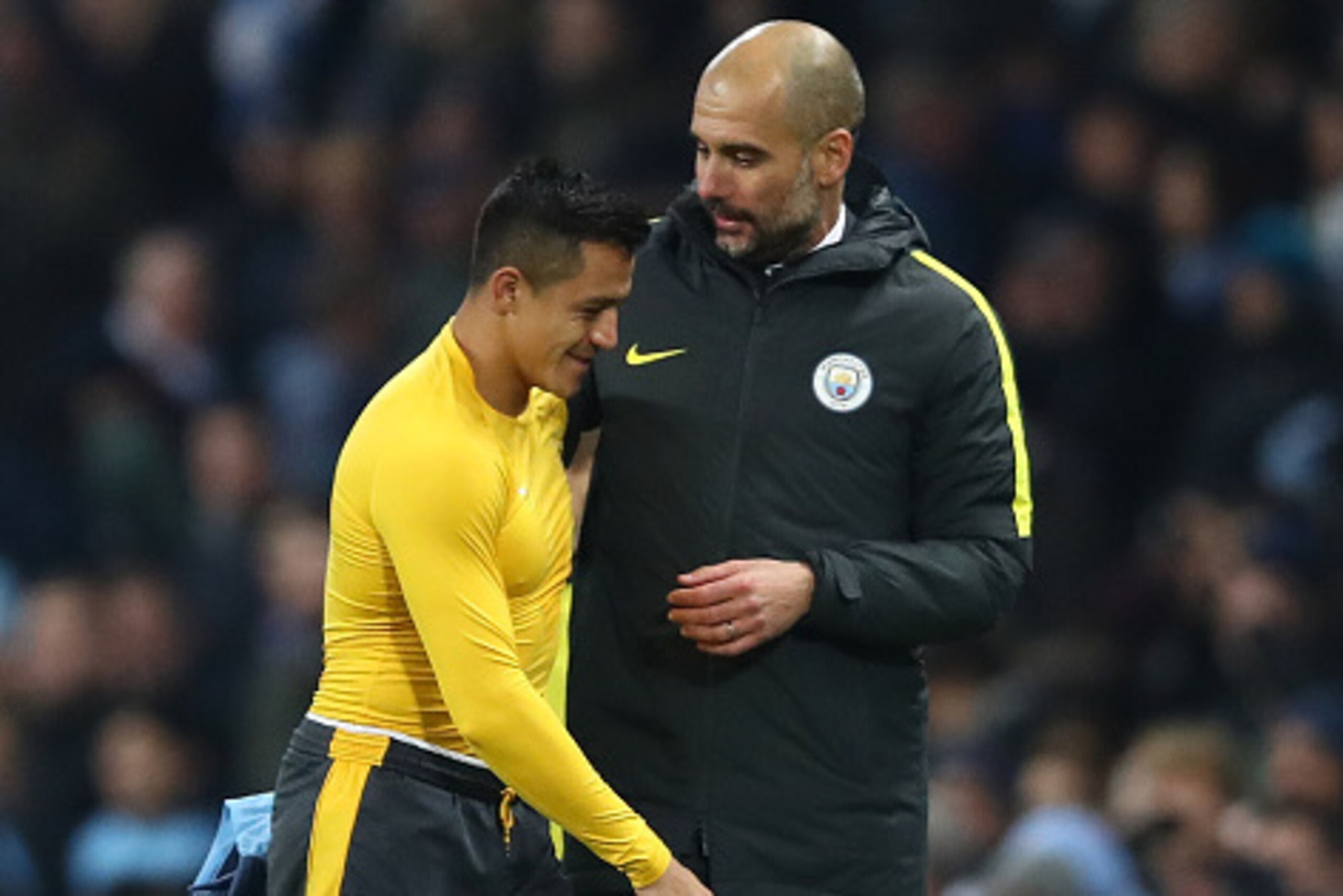 MANCHESTER, ENGLAND - DECEMBER 18:  Alexis Sanchez of Arsenal (L) and Josep Guardiola, Manager of Manchester City (R) embrace after the final whistle during the Premier League match between Manchester City and Arsenal at the Etihad Stadium on December 18,