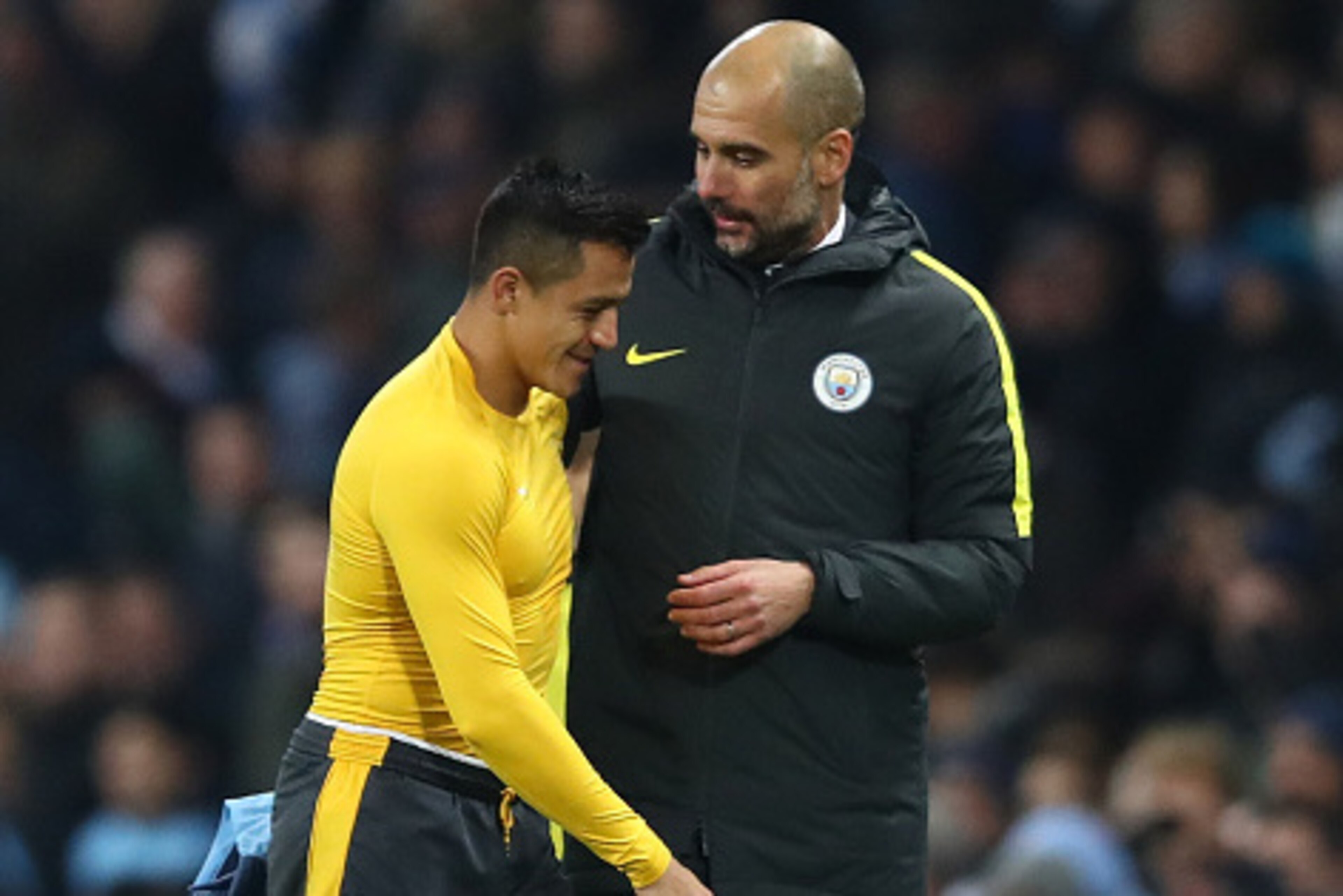 MANCHESTER, ENGLAND - DECEMBER 18:  Alexis Sanchez of Arsenal (L) and Josep Guardiola, Manager of Manchester City (R) embrace after the final whistle during the Premier League match between Manchester City and Arsenal at the Etihad Stadium on December 18,