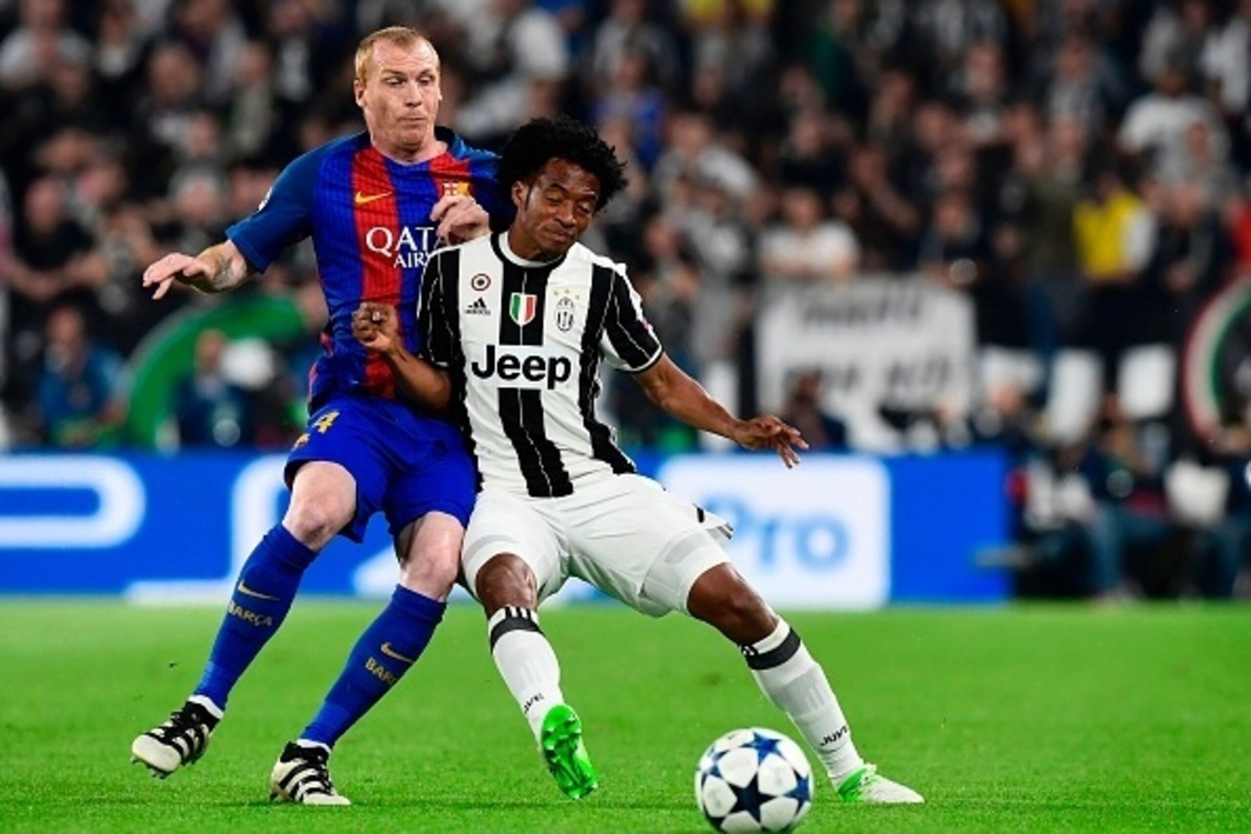 Juventus' forward from Colombia Juan Cuadrado (R) vies with Barcelona's French defender Jeremy Mathieu during the UEFA Champions League quarter final first leg football match Juventus vs Barcelona, on April 11, 2017 at the Juventus stadium in Turin.  / AF