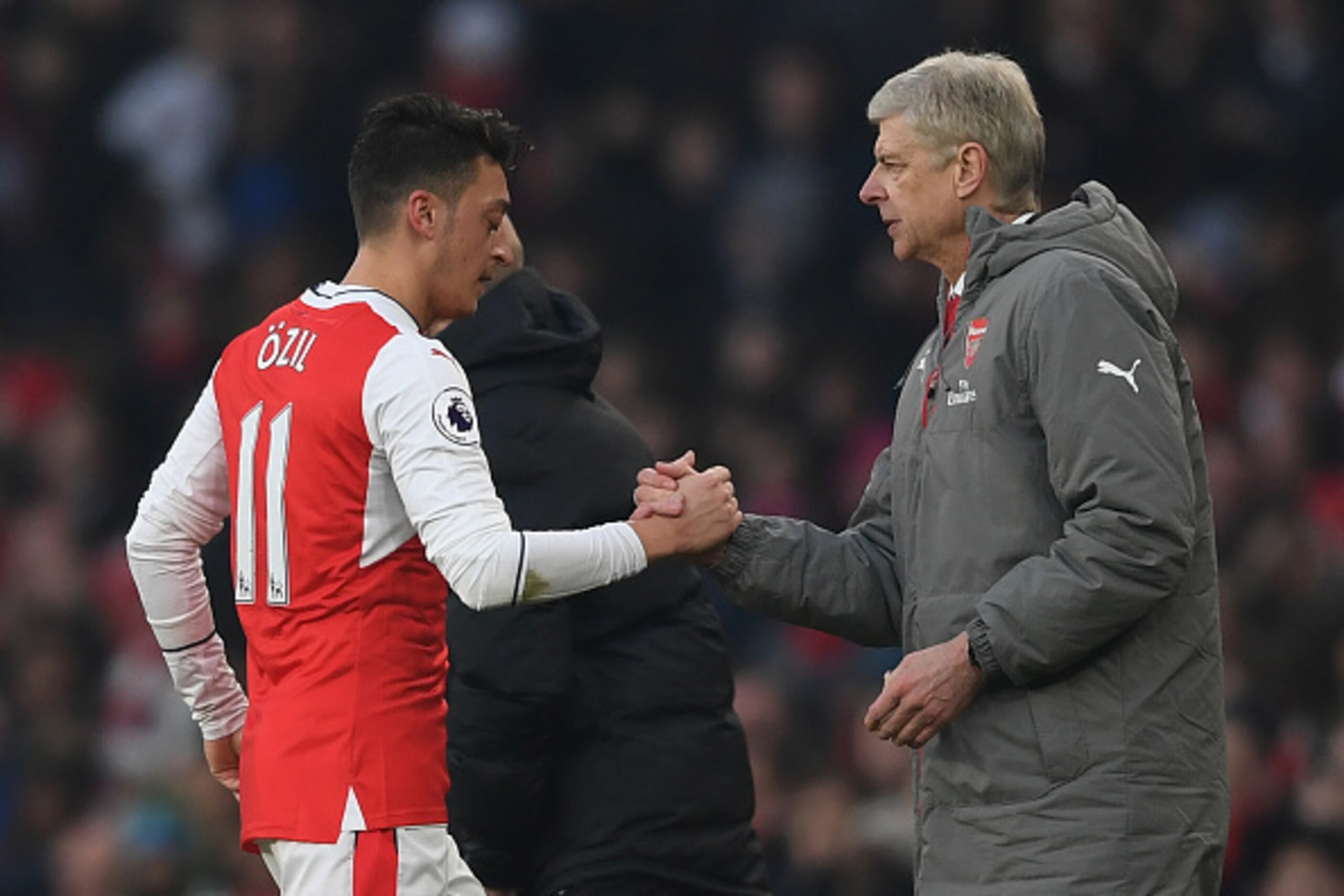LONDON, ENGLAND - JANUARY 22: Mesut Ozil of Arsenal shakes hands with Arsene Wenger, Manager of Arsenal after substituted during the Premier League match between Arsenal and Burnley at the Emirates Stadium on January 22, 2017 in London, England.  (Photo b