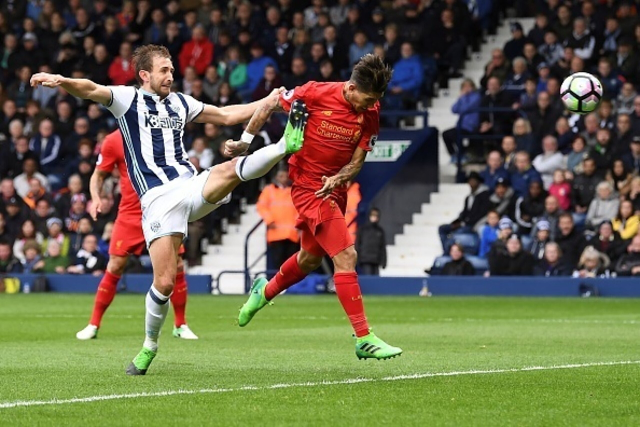 Liverpool's Brazilian midfielder Roberto Firmino (R) heads the opening goal past West Bromwich Albion's English defender Craig Dawson during the English Premier League football match between West Bromwich Albion and Liverpool at The Hawthorns stadium in W