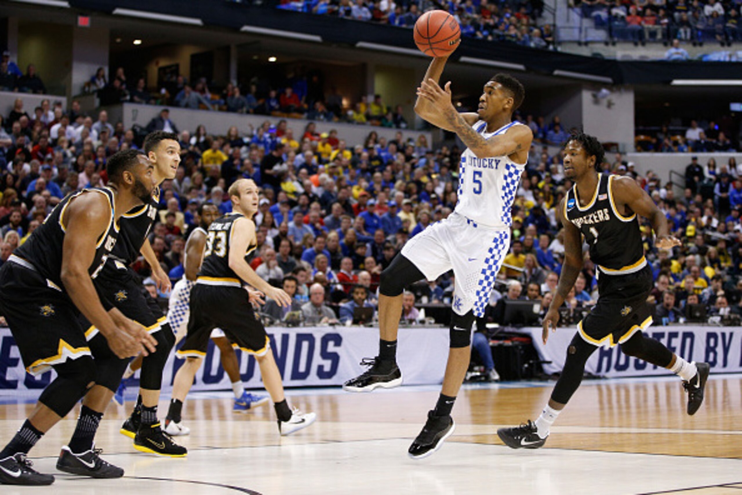 INDIANAPOLIS, IN - MARCH 19: Malik Monk #5 of the Kentucky Wildcats shoots against Shaquille Morris #24, Landry Shamet #11 and Zach Brown #1 of the Wichita State Shockers in the first half during the second round of the 2017 NCAA Men's Basketball Tourname