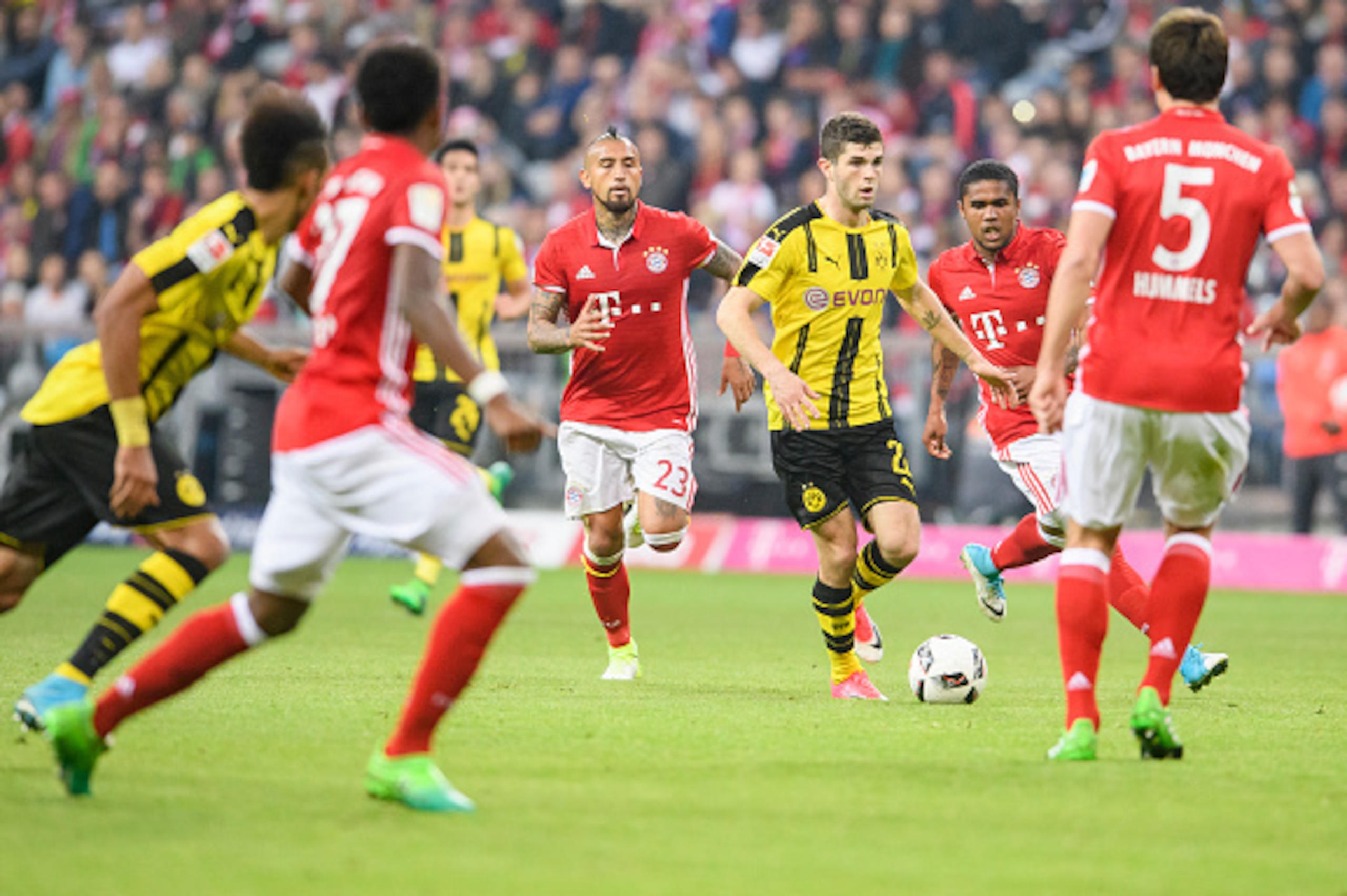 MUNICH, GERMANY - APRIL 08: Christian Pulisic of Dortmund in action against Douglas Costa of Bayern Muenchen (R) during the Bundesliga match between Bayern Muenchen and Borussia Dortmund at Allianz Arena on April 8, 2017 in Munich, Germany. (Photo by Alex
