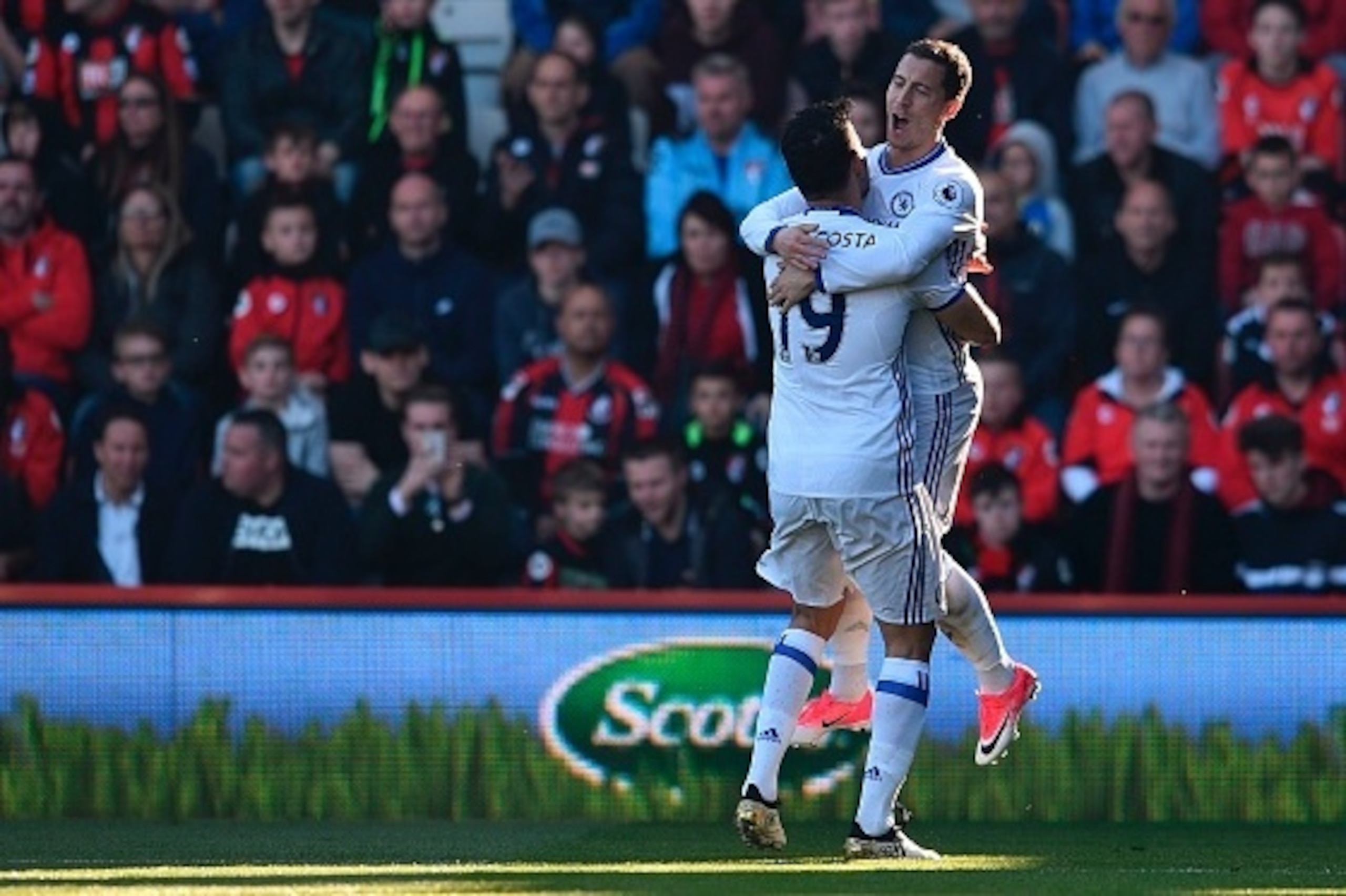 Chelsea's Belgian midfielder Eden Hazard (R) jumps into the arms of Chelsea's Brazilian-born Spanish striker Diego Costa (L) as he celebrates scoring their second goal during the English Premier League football match between Bournemouth and Chelsea at the
