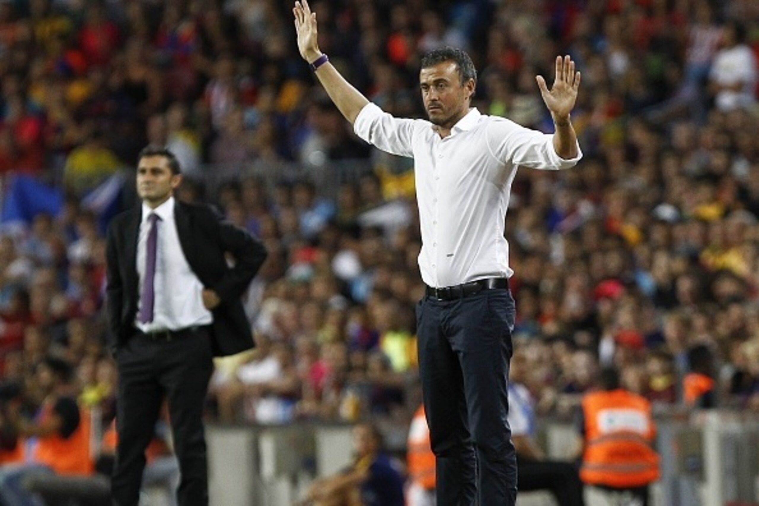 Barcelona's coach Luis Enrique (R) gives instructions to his players next to Athletic Bilbao's coach Ernesto Valverde during the Spanish Supercup second-leg football match FC Barcelona vs Athletic Club Bilbao at the Camp Nou stadium in Barcelona on August