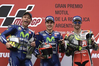 The winner, Yamaha's Spanish biker Maverick Vinales (C), 2nd placed --also from Yamaha--Italian Valentino Rossi (L) and 3rd placed Honda biker Cal Crutchlow from the UK celebrate on the podium of the MotoGP race of the Argentina Grand Prix at Termas de Ri