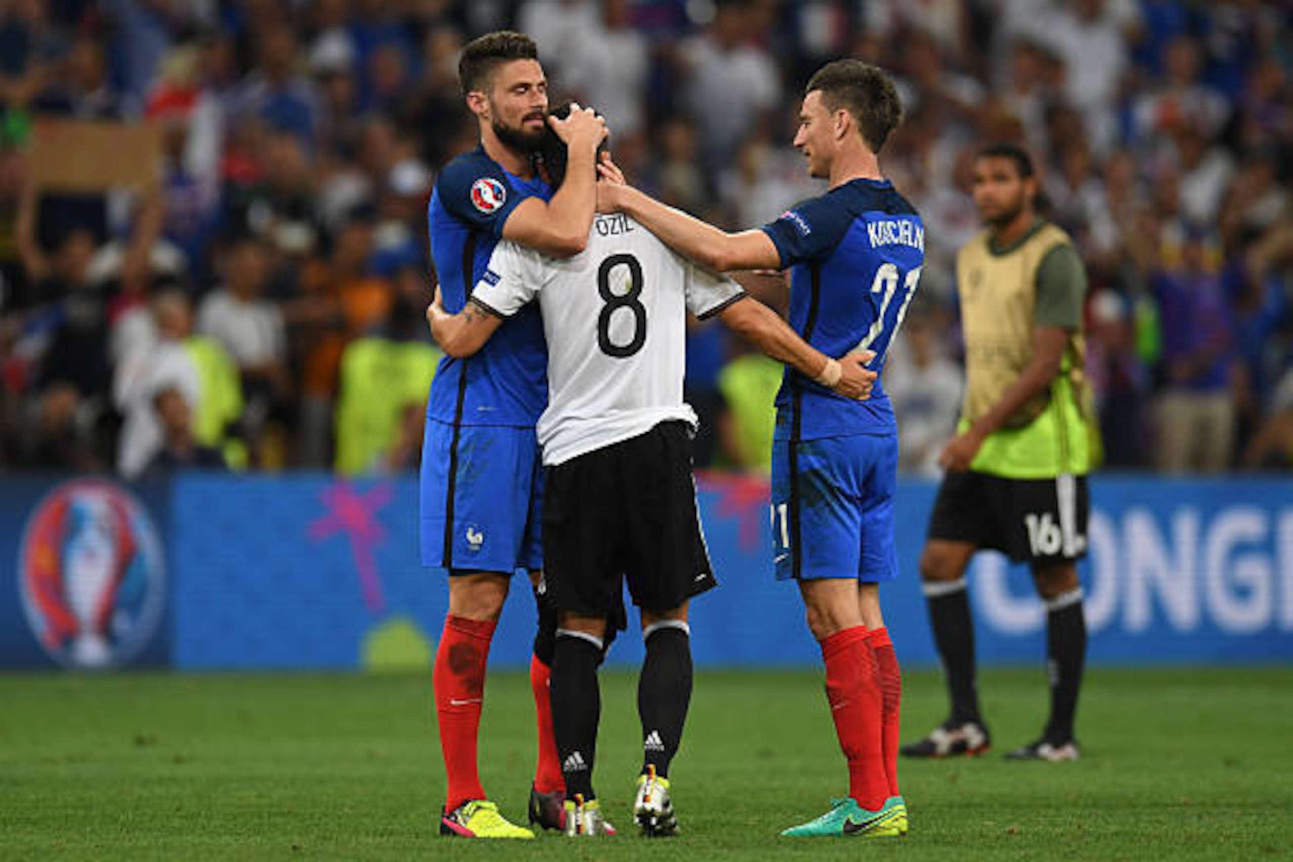 France's forward Olivier Giroud (L) and France's defender Laurent Koscielny (R) consol Germany's midfielder Mesut Oezil after France beat Germany 2-0 in the Euro 2016 semi-final football match between Germany and France at the Stade Velodrome in Marseille