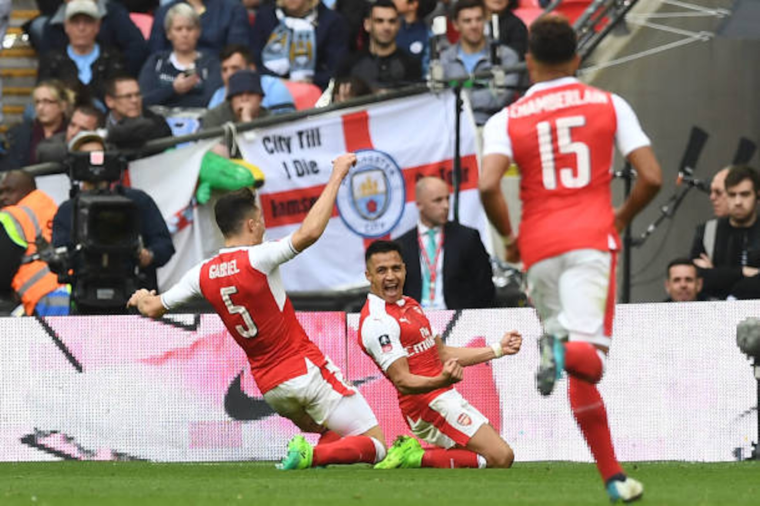 Arsenal's Chilean striker Alexis Sanchez (C) celebrates scoring their second goal with Arsenal's Brazilian defender Gabriel (L) during the FA Cup semi-final football match between Arsenal and Manchester City at Wembley stadium in London on April 23, 2017.