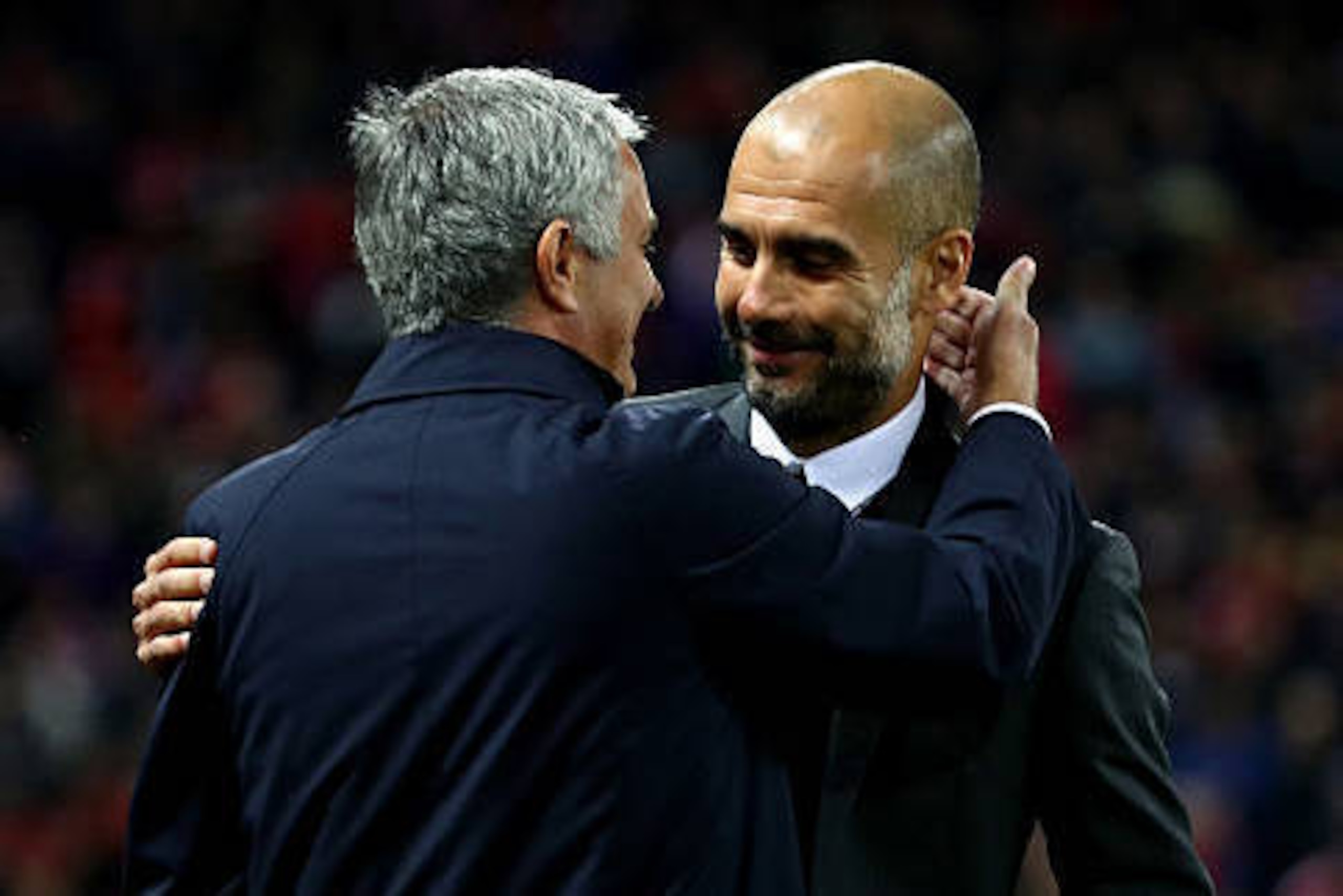 MANCHESTER, ENGLAND - OCTOBER 26: Jose Mourinho, Manager of Manchester United (L) and Josep Guardiola, Manager of Manchester City (R) embrace prior to kick off during the EFL Cup fourth round match between Manchester United and Manchester City at Old Traf