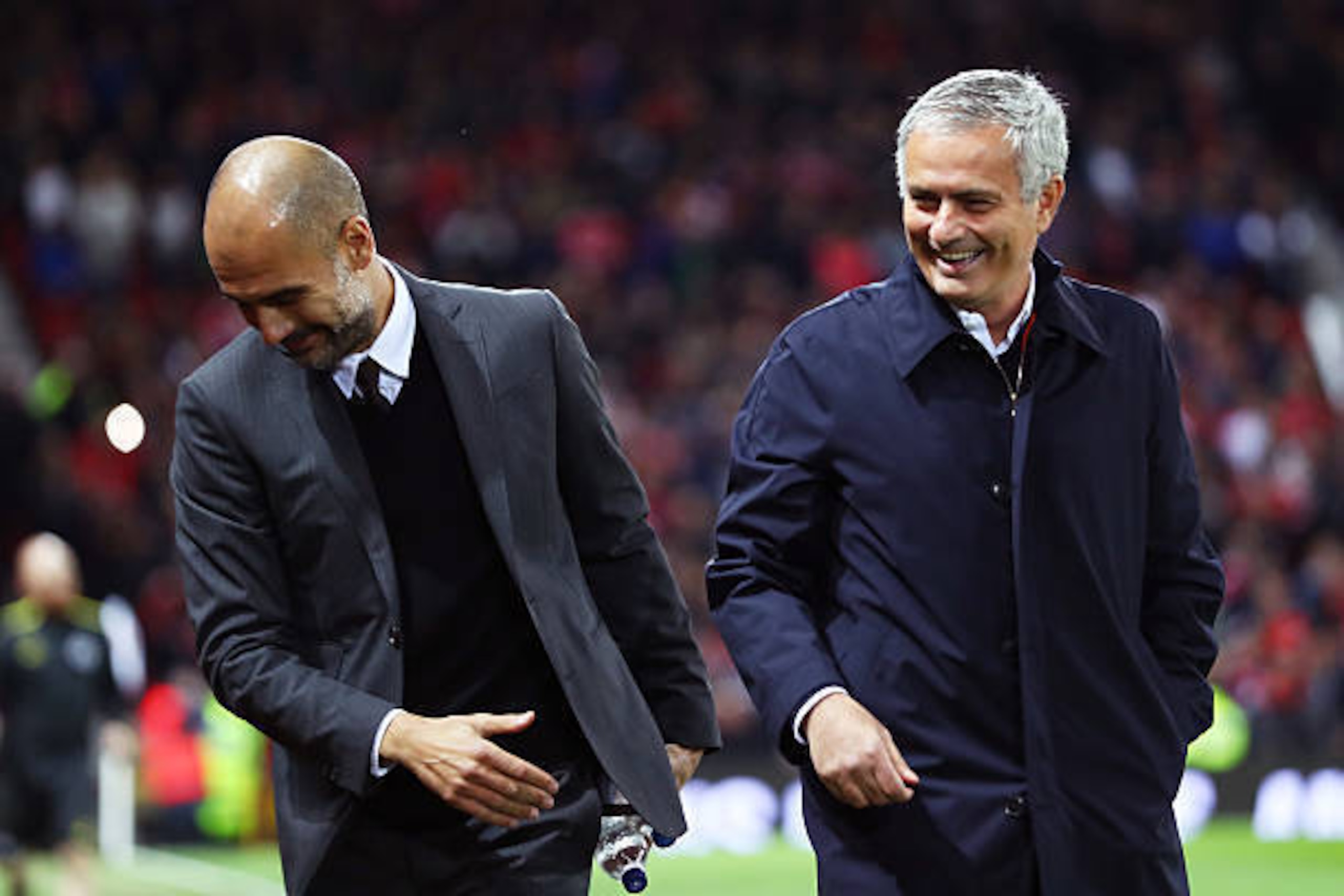 MANCHESTER, ENGLAND - OCTOBER 26: Josep Guardiola, Manager of Manchester City (L) and Jose Mourinho, Manager of Manchester United (R) share a joke prior to kick off during the EFL Cup fourth round match between Manchester United and Manchester City at Old