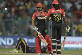 Royal Challengers Bangalore captain Virat Kohli (L) talks with Chris Gayle as Kolkata Knight Riders Andre Russell falls  during the 2016 Indian Premier League (IPL) Twenty20 cricket match between Kolkata Knight Riders and Royal Challengers Bangalore at th