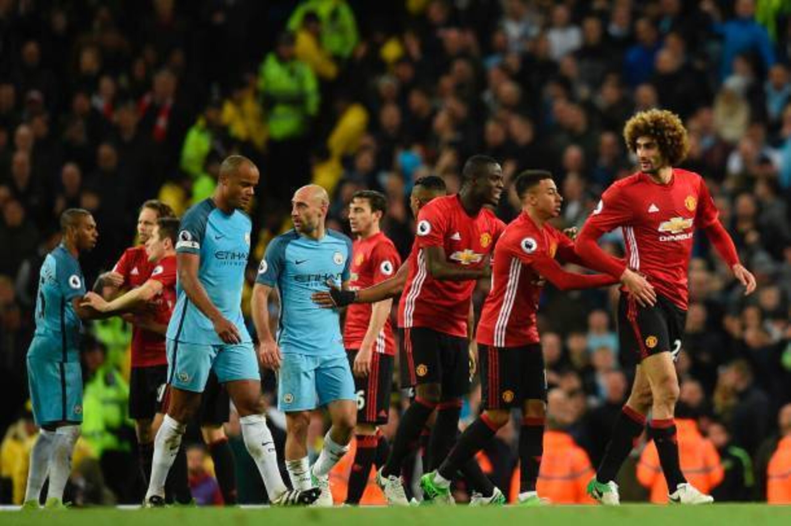 Manchester United's Belgian midfielder Marouane Fellaini (R) is shepherded away after being sent off during the English Premier League football match between Manchester City and Manchester United at the Etihad Stadium in Manchester, north west England, on