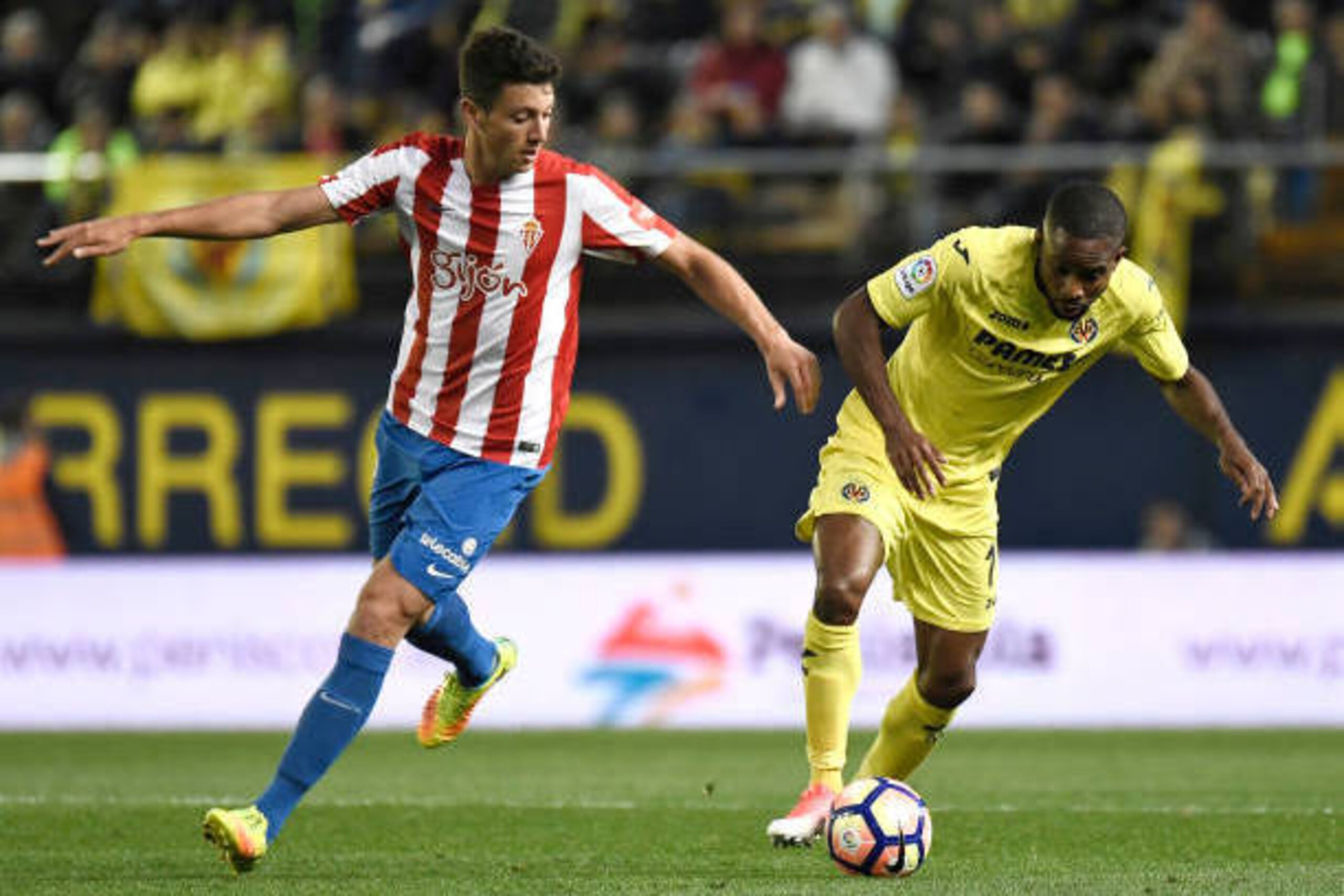 Sporting Gijon's midfielder Mikel Vesga (L) vies with Villarreal's Congolese forward Cedric Bakambu during the Spanish league football match Villarreal CF vs Real Sporting de Gijon at La Ceramica stadium in Villareal on April 28, 2017. / AFP PHOTO / JOSE 