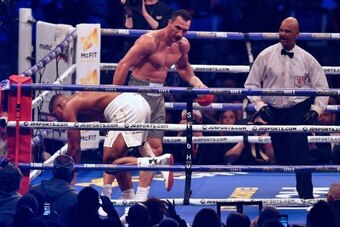 Referee David Fields (R) prepares to step in as Ukraine's Wladimir Klitschko (C) puts Britain's Anthony Joshua on the canvass in round six of their IBF, IBO and WBA, world Heavyweight title fight at Wembley Stadium in north west London on April 29, 2017. 