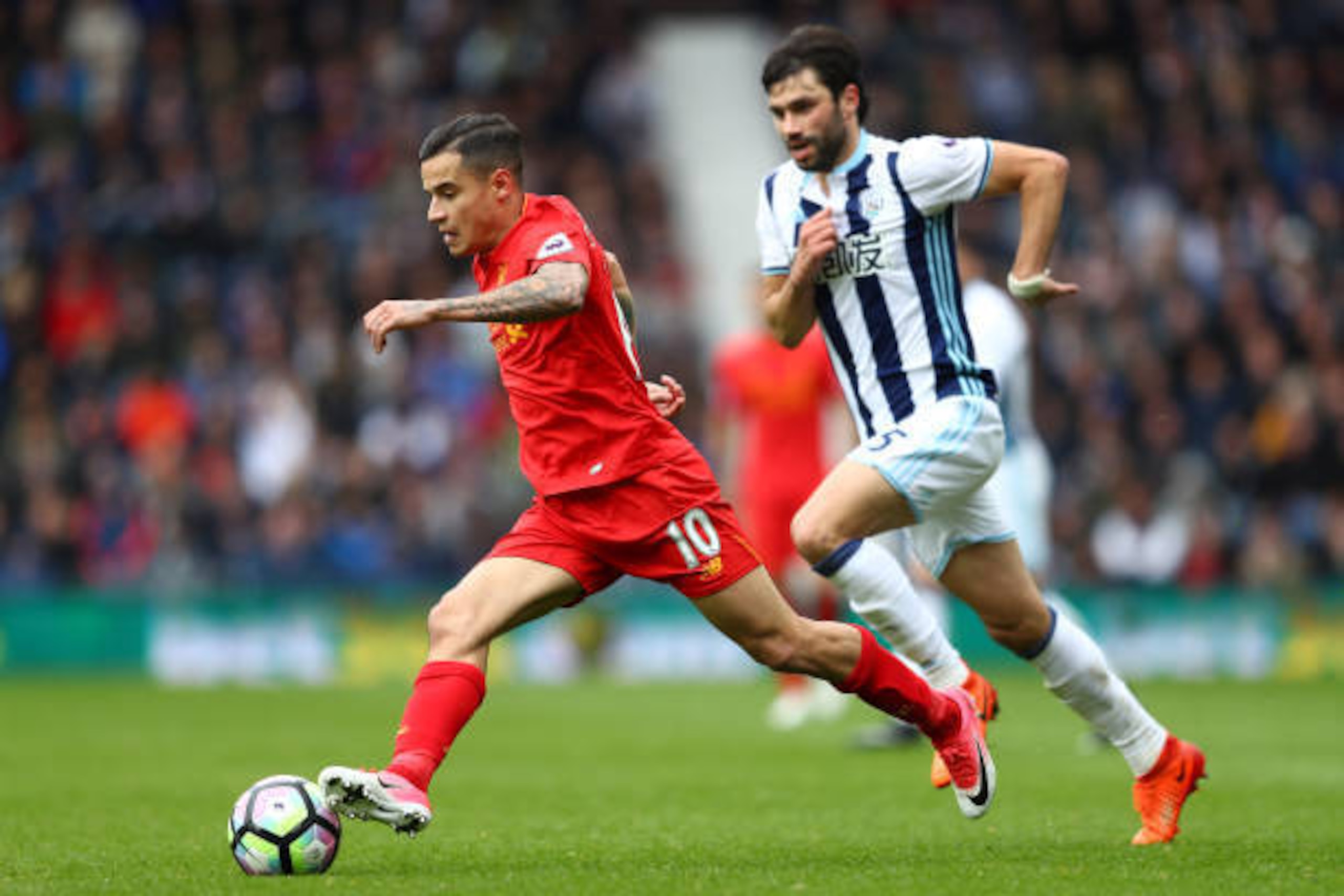 WEST BROMWICH, ENGLAND - APRIL 16: Philippe Coutinho of Liverpool takes the ball past Claudio Yacob of West Bromwich Albion during the Premier League match between West Bromwich Albion and Liverpool at The Hawthorns on April 16, 2017 in West Bromwich, Eng