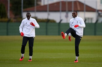 LIVERPOOL, ENGLAND - MARCH 09:  Christian Benteke of Liverpool stretches with team-mate Mamadou Sakho of Liverpool during a training session ahead of the UEFA Europa League round of 16 first leg match between Liverpool and Manchester United at Melwood Tra