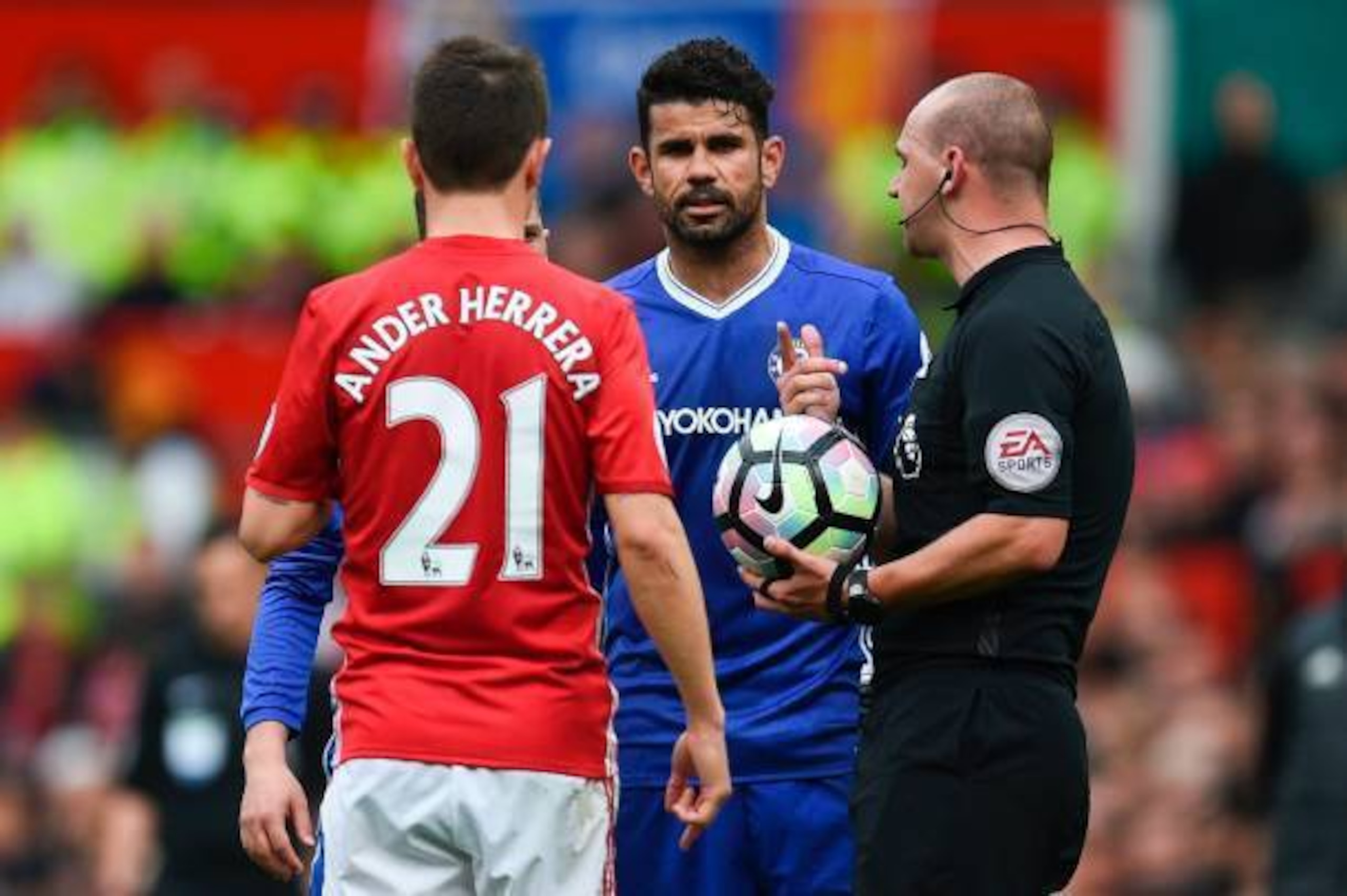 Manchester United's Spanish midfielder Ander Herrera (L) and Chelsea's Brazilian-born Spanish striker Diego Costa (C) talk with referee Robert Madley (R) during the English Premier League football match between Manchester United and Chelsea at Old Traffor