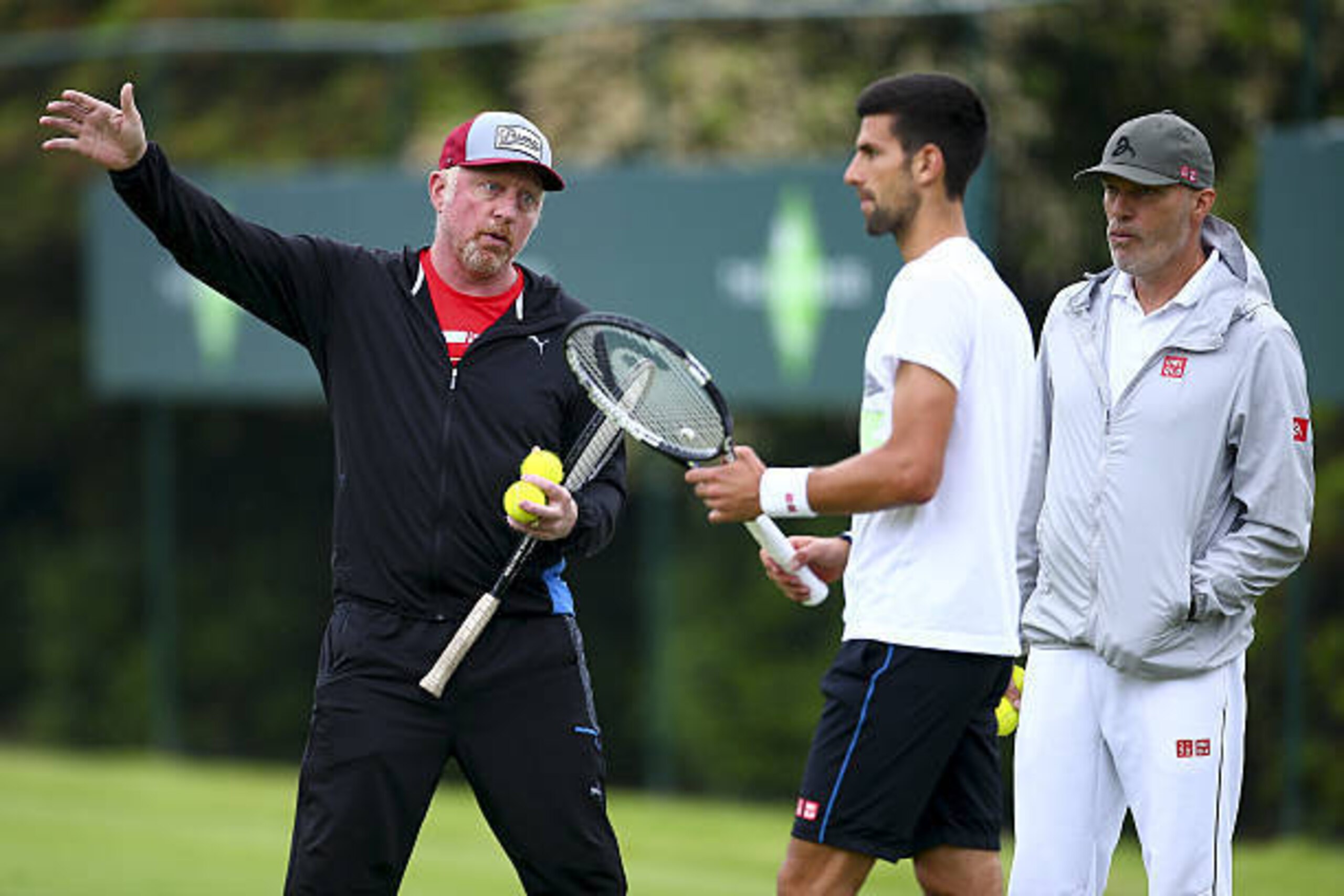 STOKE POGES, ENGLAND - JUNE 22:  Novak Djokovic of Serbia (C) talks with his coach Boris Boris Becker (L) and his fitness coach Gebhard Phil-Gritsch trainer (R) during a practice session during day two of The Boodles Tennis Event at Stoke Park on June 22,
