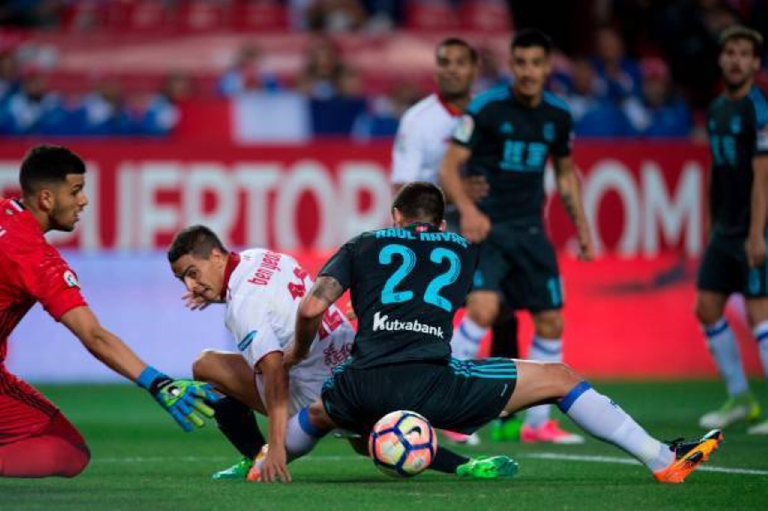 Real Sociedad's Argentinian goalkeeper Geronimo Rulli (L) and defender Raul Navas (R) vie with Sevilla's French Tunisian forward Wissam Ben Yedder  during the Spanish league football match Sevilla FC vs Real Sociedad at the Ramon Sanchez Pizjuan stadium i