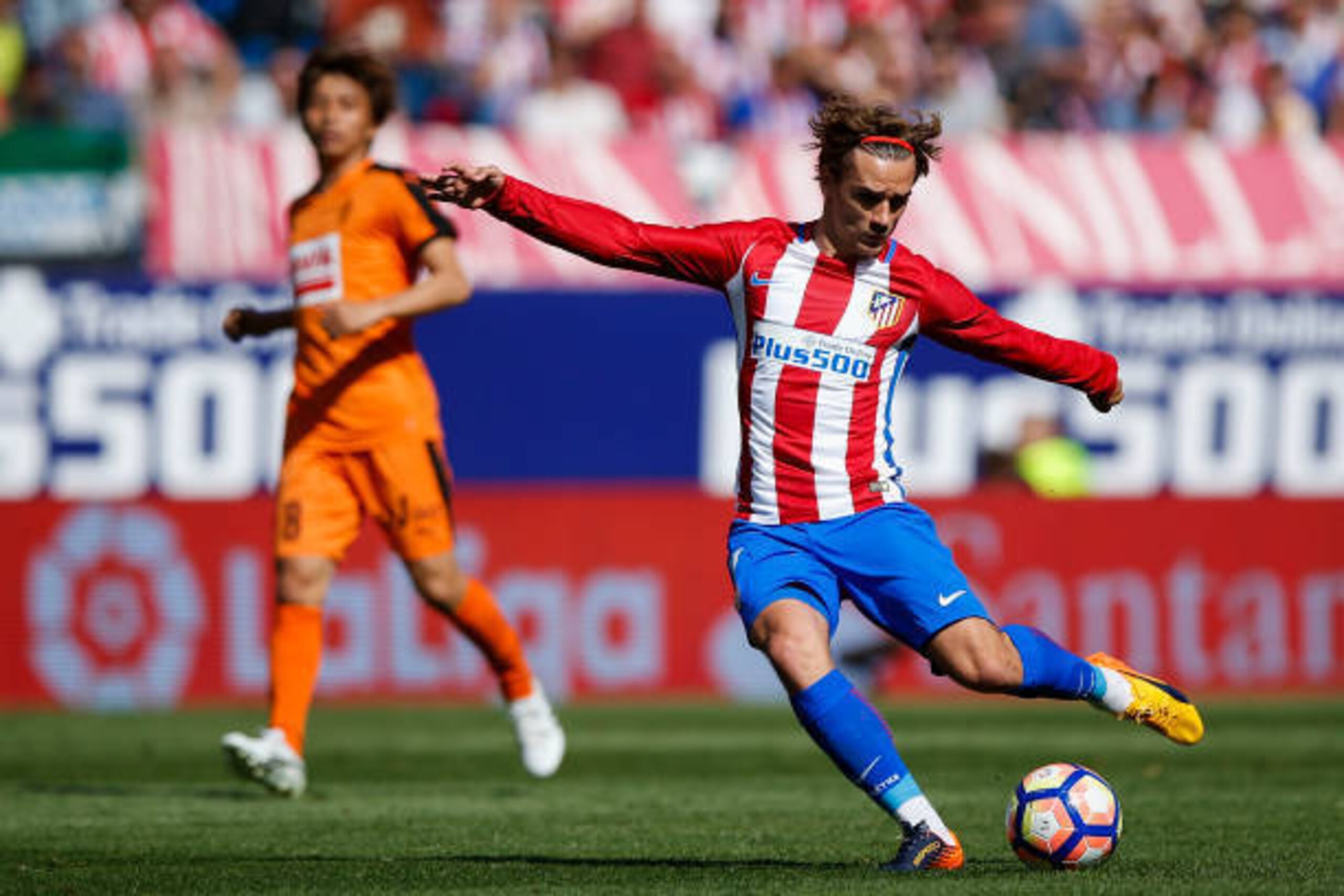 MADRID, SPAIN - MAY 06: Antoine Griezmann (R) of Atletico de Madrid strikes the ball ahead Takashi Inui (L) of SD Eibar during the La Liga match between Club Atletico de Madrid and SD Eibar at Estadio Vicente Calderon on May 6, 2017 in Madrid, Spain.  (Ph