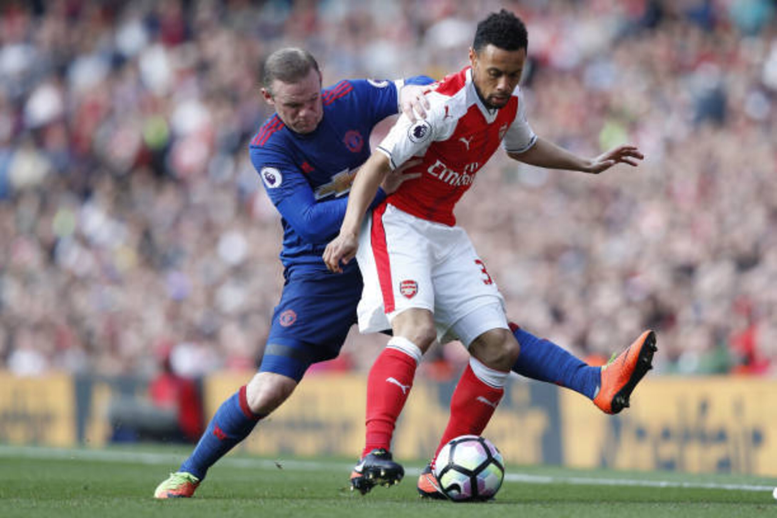 Manchester United's English striker Wayne Rooney (L) tackles Arsenal's French midfielder Francis Coquelin during the English Premier League football match between Arsenal and Manchester United at the Emirates Stadium in London on May 7, 2017.  / AFP PHOTO