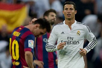 MADRID, SPAIN - OCTOBER 25: Cristiano Ronaldo (R) of Real Madrid CF walks on after celebrating his team's third goal close to Lionel Messi (R) of FC Barcelonar reacting defeated  during the La Liga match between Real Madrid CF and FC Barcelona at Estadio 