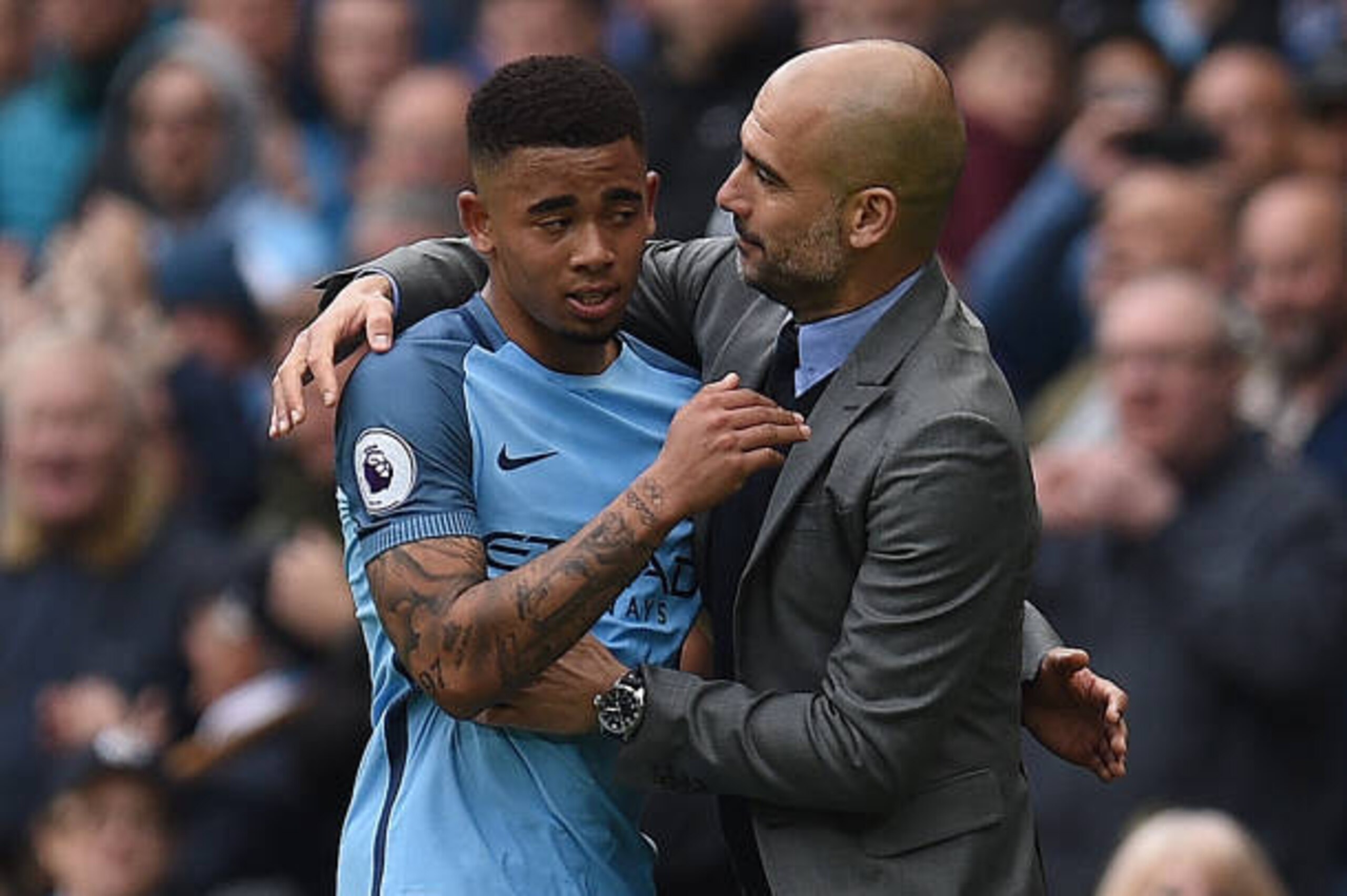 Manchester City's Brazilian striker Gabriel Jesus (L) is hugged by Manchester City's Spanish manager Pep Guardiola as he substituted off of the pitch during the English Premier League football match between Manchester City and Crystal Palace at the Etihad