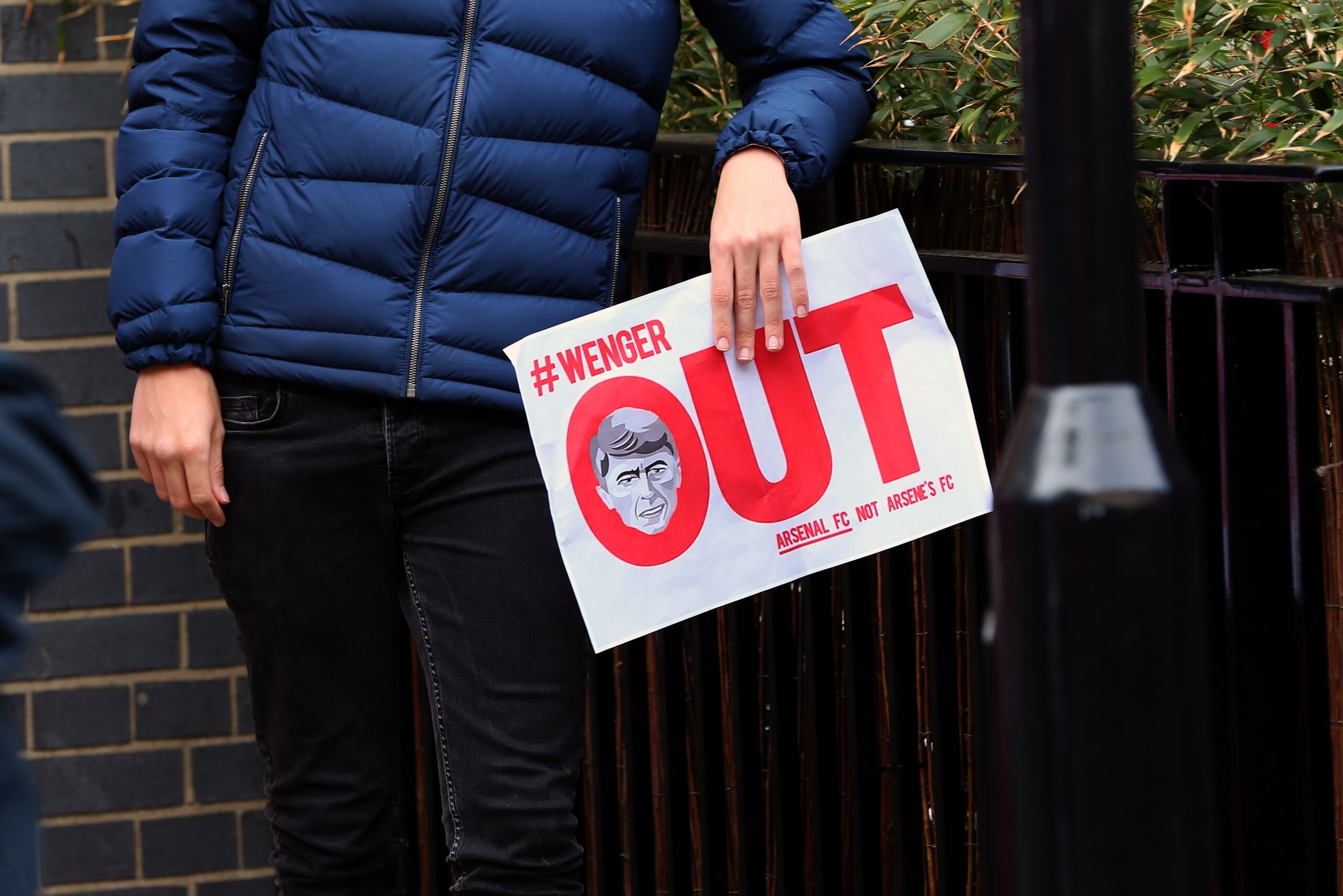 LONDON, ENGLAND - MAY 07: A fan holds a 'Wenger Out' flyer to protest against Arsene Wenger manager / head coach of Arsenal before the Premier League match between Arsenal and Manchester United at Emirates Stadium on May 7, 2017 in London, England. (Photo