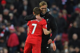 Liverpool's German manager Jurgen Klopp (R) embraces Liverpool's English midfielder James Milner after the English Premier League football match between Liverpool and Burnley at Anfield in Liverpool, north west England on March 12, 2017.
Liverpool won the