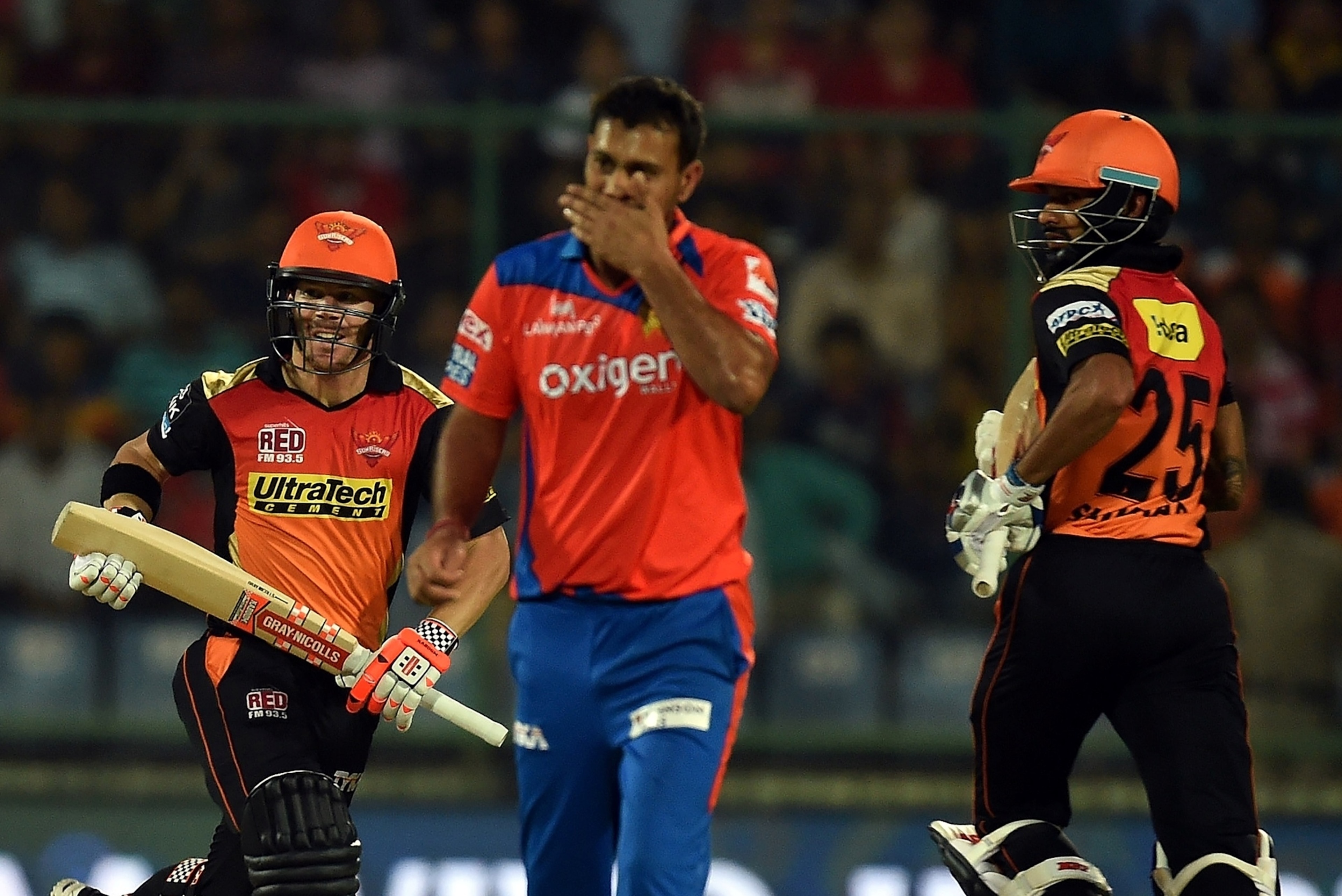 Gujarat Lions Praveen Kumar (C) gestures as Sunrisers Hyderabad captain David Warner (L) and Shikhar Dhawan (R) run between the wickets during the 2016 Indian Premier League (IPL) Twenty20 qualifier cricket match between Gujarat Lions and Sunrisers Hydera