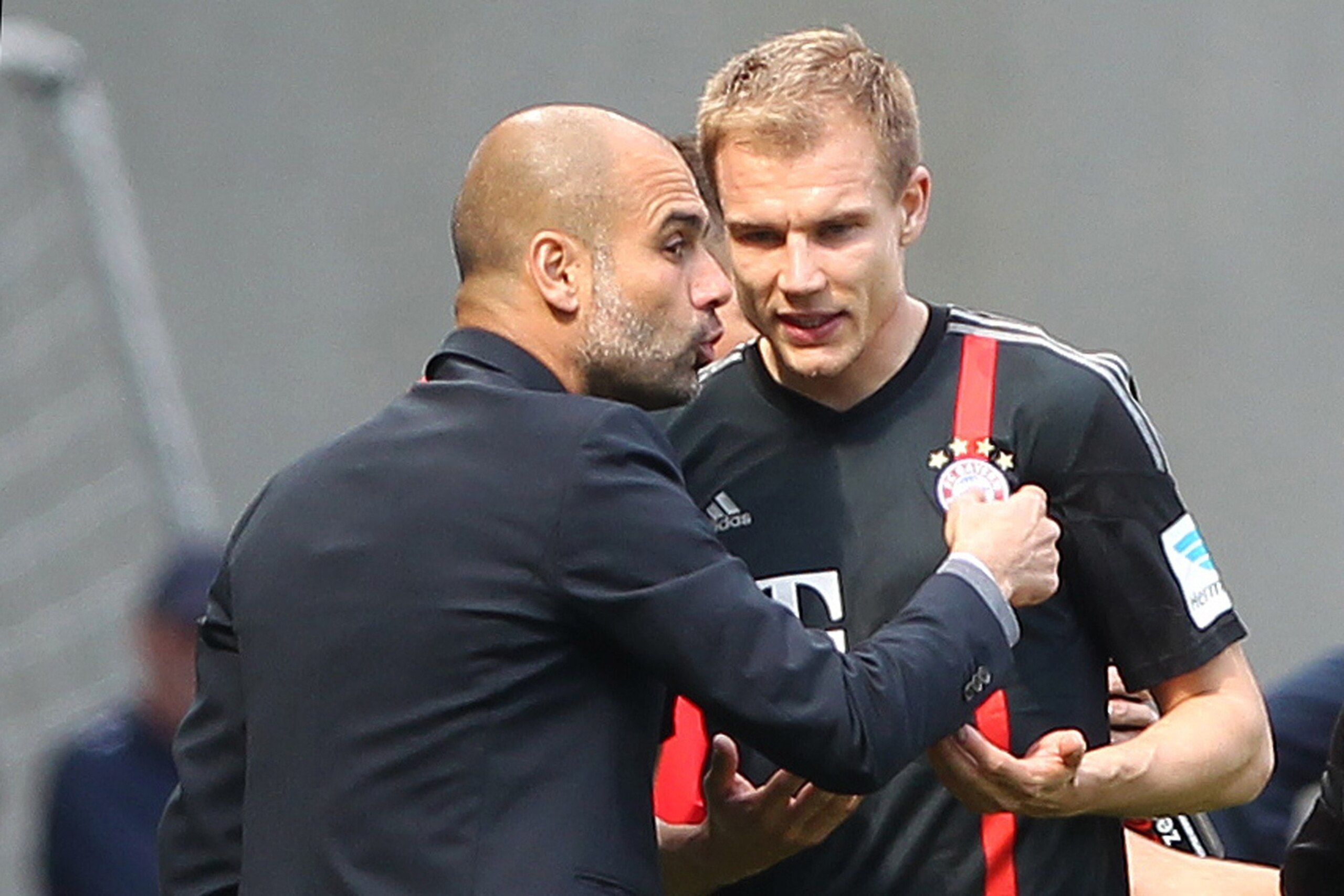 Bayern Munich's Spanish head coach Pep Guardiola (L) talks with Bayern Munich's defender Holger Badstuber during the German first division Bundesliga football match 1899 Hoffenheim vs FC Bayern Munich in Sinsheim, southern Germany, on April 18, 2015. AFP 