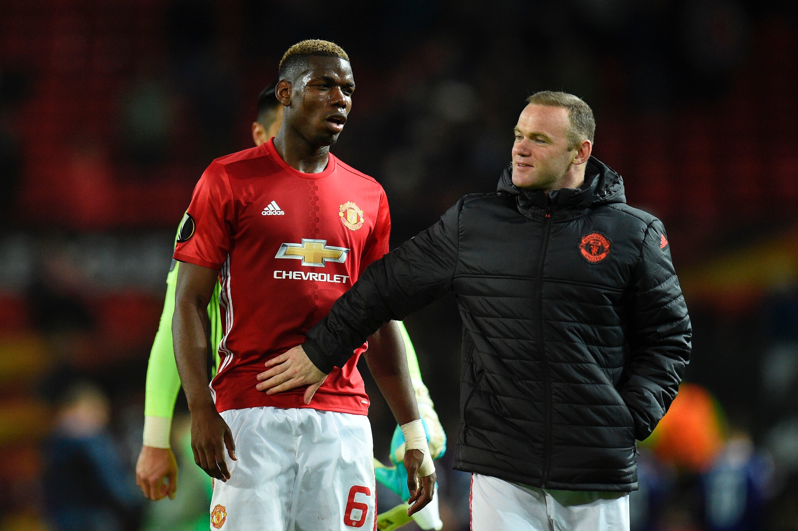 Manchester United's English striker Wayne Rooney pats team mate Paul Pogba as they walk off the pitch at full time of the UEFA Europa League quarter-final second leg football match between Manchester United and Anderlecht at Old Trafford in Manchester, no