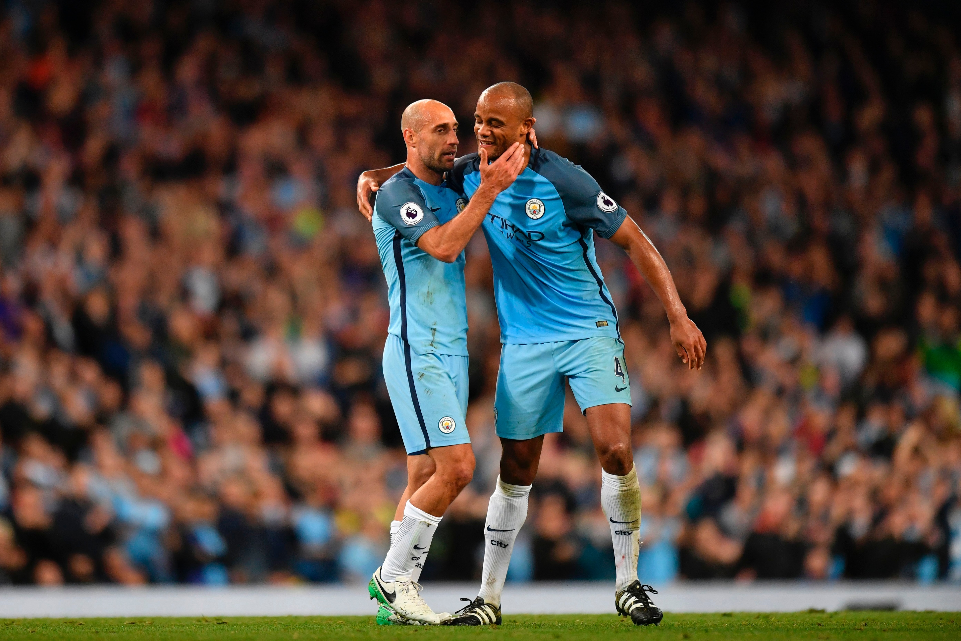 Manchester City's Argentinian defender Pablo Zabaleta (L) embraces Manchester City's Belgian defender Vincent Kompany (R) as Kompany hands him the captain's armband as he goes off the field substituted during the English Premier League football match betw