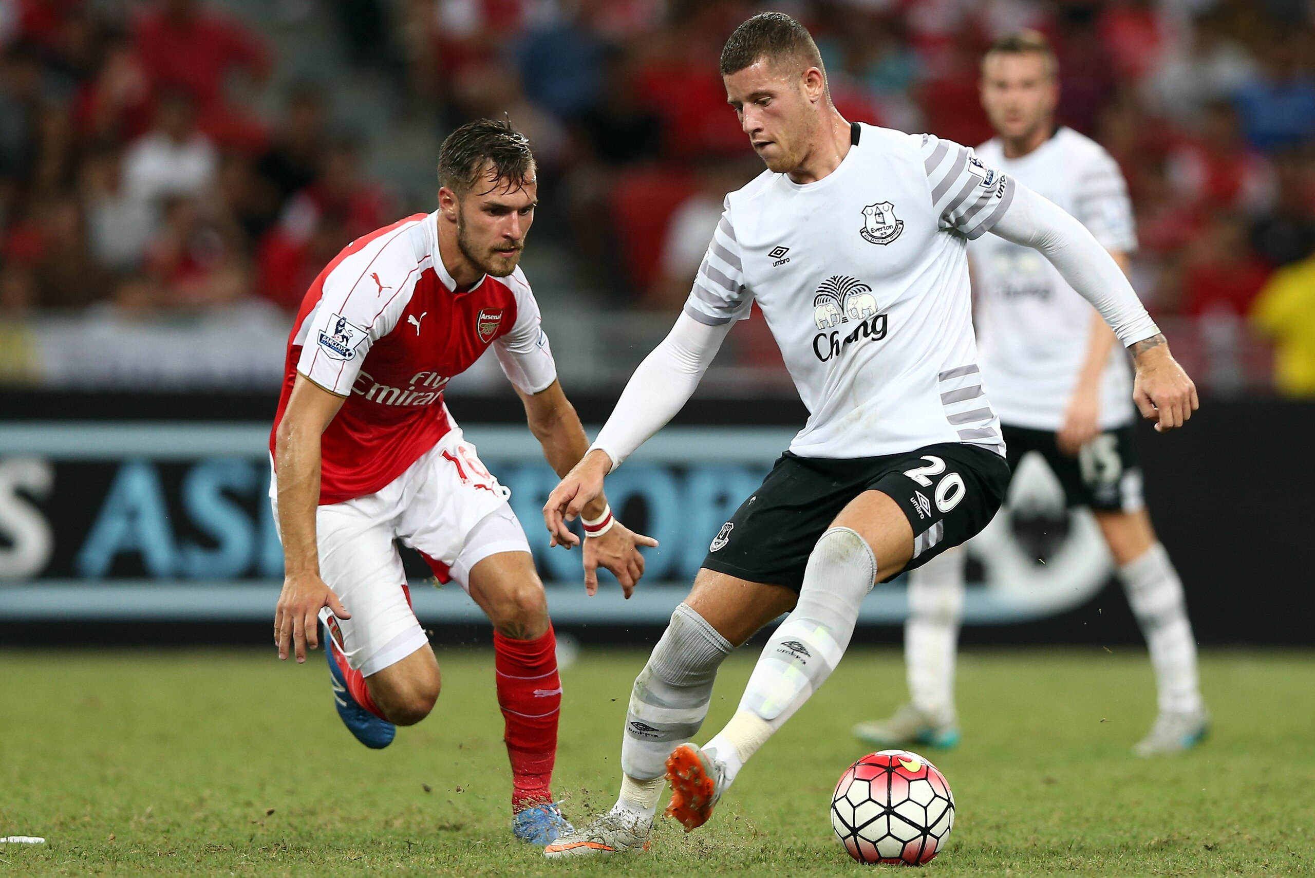 SINGAPORE - JULY 18: Aaron Ramsey of Arsenal  challenges Ross Barkley of Everton during the Barclays Asia Trophy final match between Arsenal and Everton at the National Stadium on July 18, 2015 in Singapore.  (Photo by Stanley Chou/Getty Images)