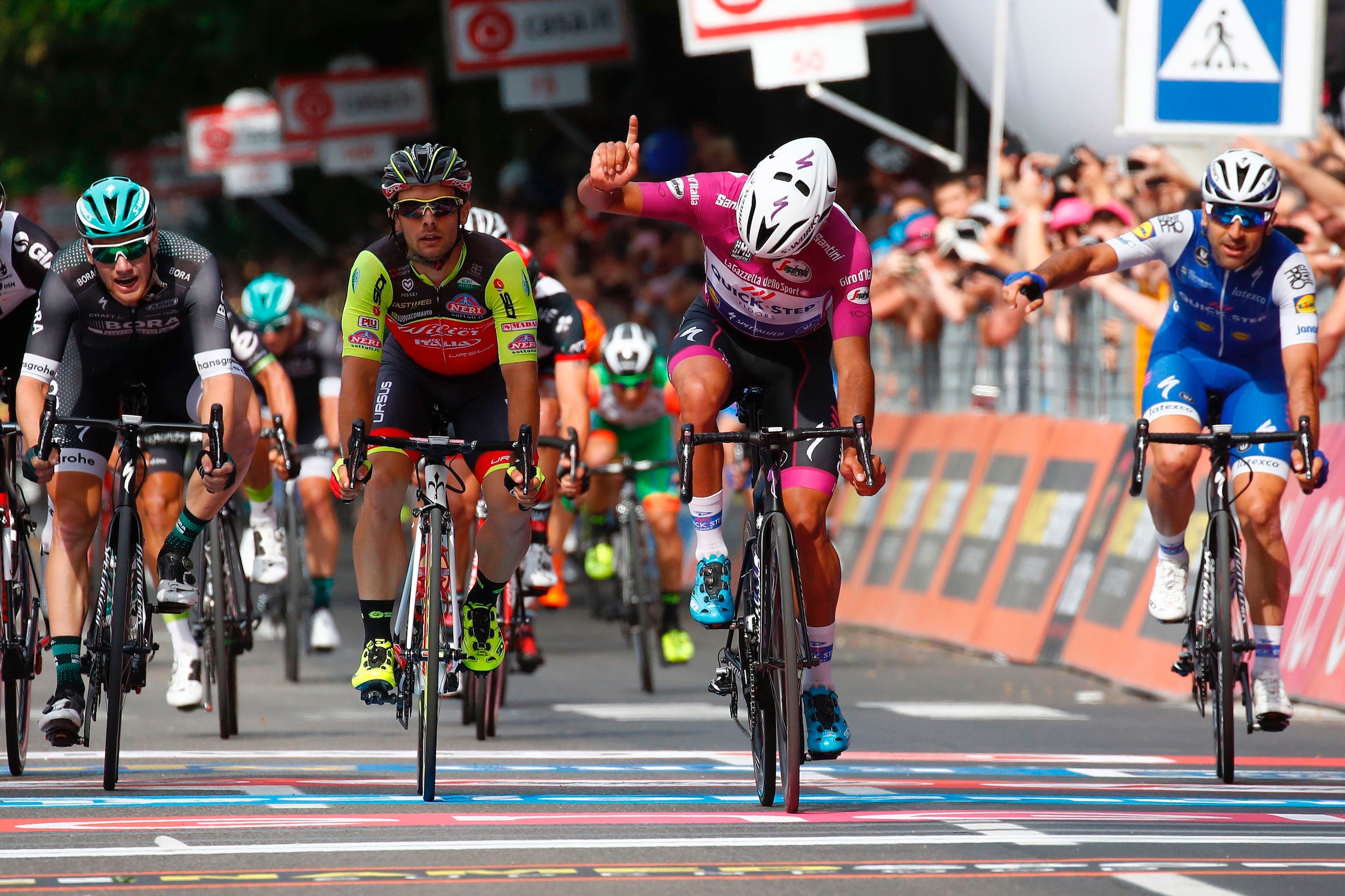 Colombian cyclist Fernando Gaviria (C) from QuickStep - Floors reacts as he crosses the finish line to win the 12th stage of the 100th Giro d'Italia, Tour of Italy cycling race from Forl?i to Reggio Emilia of 100th Giro d'Italia, Tour of Italy on May 18, 