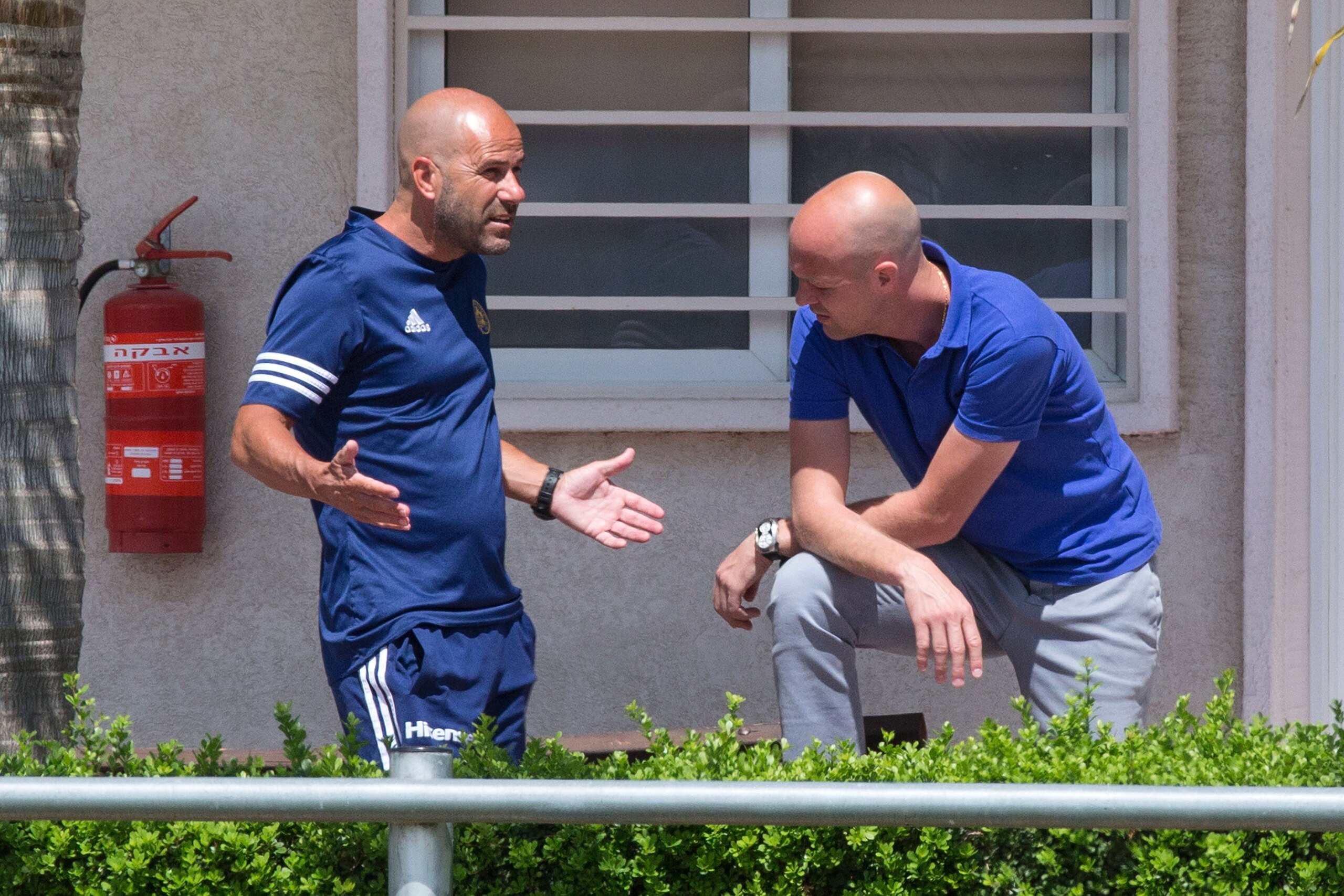 Maccabi Tel Aviv football club's head coach, Dutch Peter Bosz (L) talks with his Sports Director, Dutch Jordi Cruyff during a training session on May 19, 2016 at the Maccabi Tel Aviv training ground in south Tel Aviv. / AFP / JACK GUEZ        (Photo credi