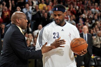 CLEVELAND - MARCH 21:  LeBron James #23 of the Cleveland Cavaliers reaches out to shake head coach Mike Brown's hand after receiving the game ball from when LeBron became the youngest player in NBA history to record 15,000 points just prior to the start o