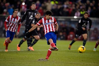 Atletico Madrid's Brazilian forward Diego da Silva Costa scores on a penalty kick during the Spanish league football match Club Atletico de Madrid vs Levante UD at the Vicente Calderon stadium in Madrid on December 21, 2013.   AFP PHOTO/ DANI POZO        