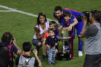 TOPSHOT - Barcelona's Argentinian forward Lionel Messi (C), his wife Antonella Roccuzzo and sons pose with the trophy at the end of the Spanish Copa del Rey (King's Cup) final football match FC Barcelona vs Deportivo Alaves at the Vicente Calderon stadium