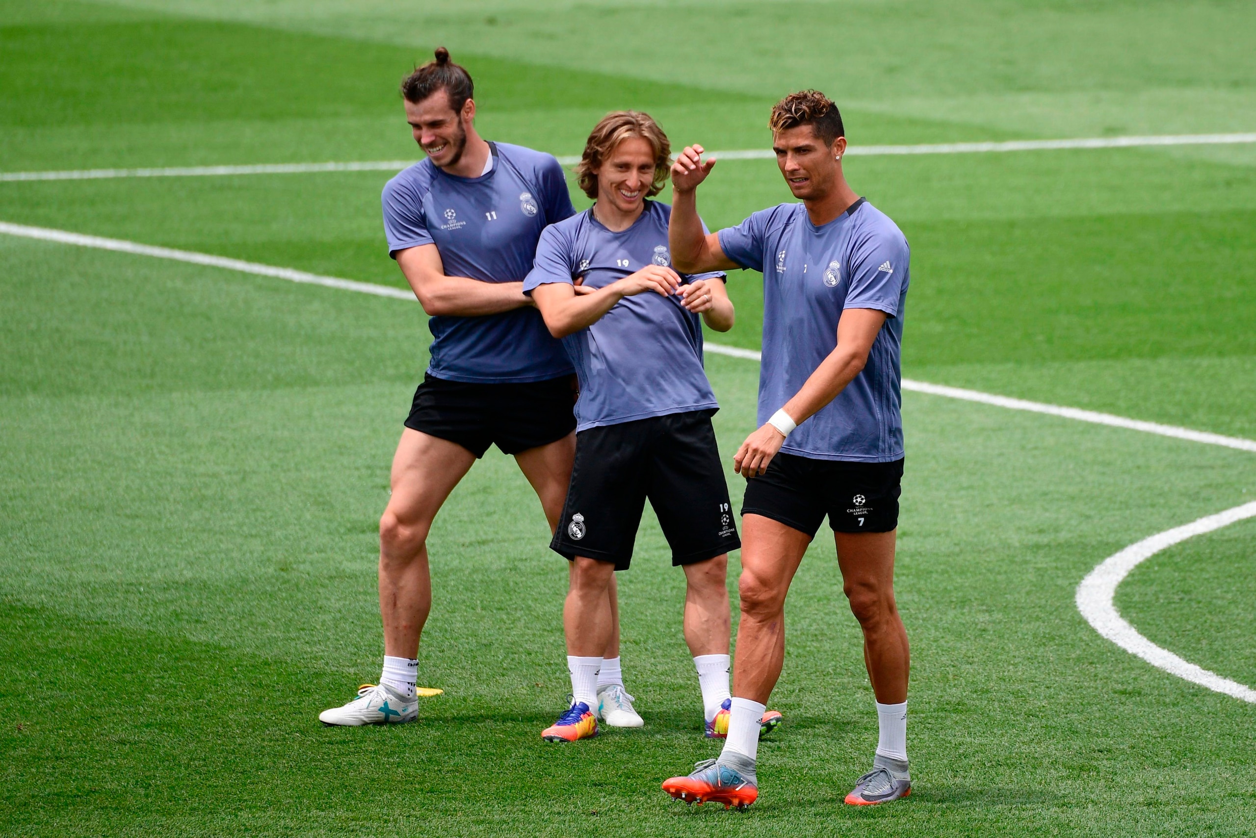 Real Madrid's Welsh forward Gareth Bale (L), Real Madrid's Croatian midfielder Luka Modric (C) and Real Madrid's Portuguese forward Cristiano Ronaldo (R) joke during a training session at Valdebebas Sport City in Madrid on May 30, 2017 at the Media Day ev